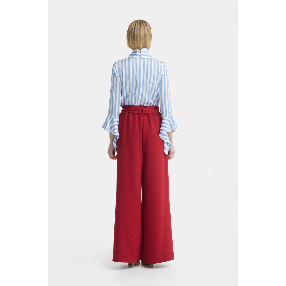 A person stands facing away in a light blue and white vertically striped blouse with flared sleeves and JULIA ALLERT Belted High Waist Wide Leg Pants - Burgundy against a plain white background.