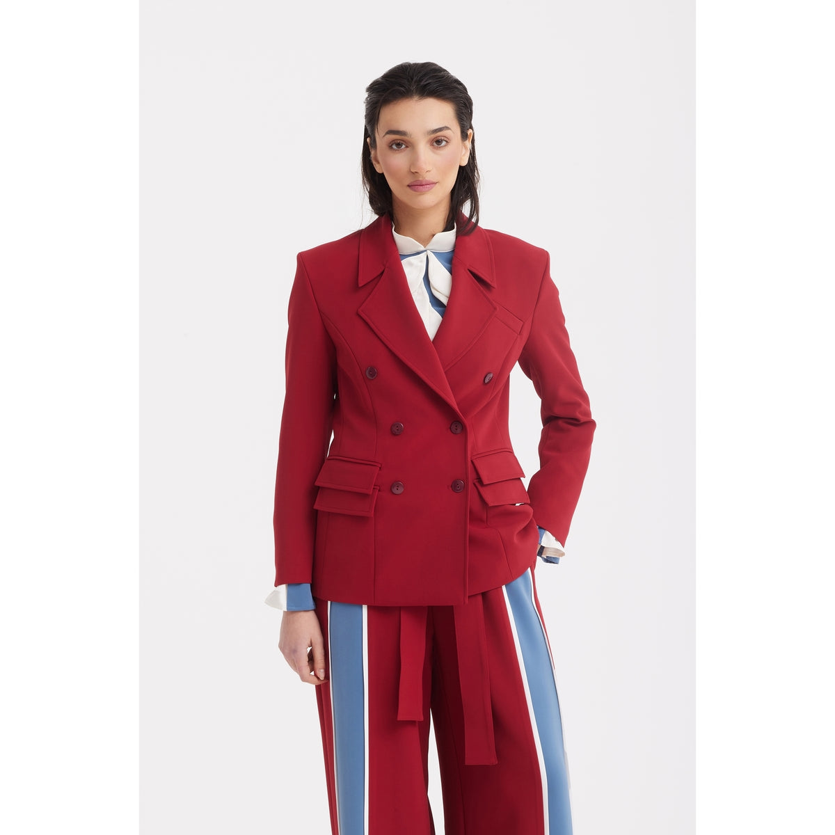A woman with dark hair styled back and a neutral expression stands against a white background wearing JULIA ALLERT Belted High Waist Wide Leg Pants in burgundy.