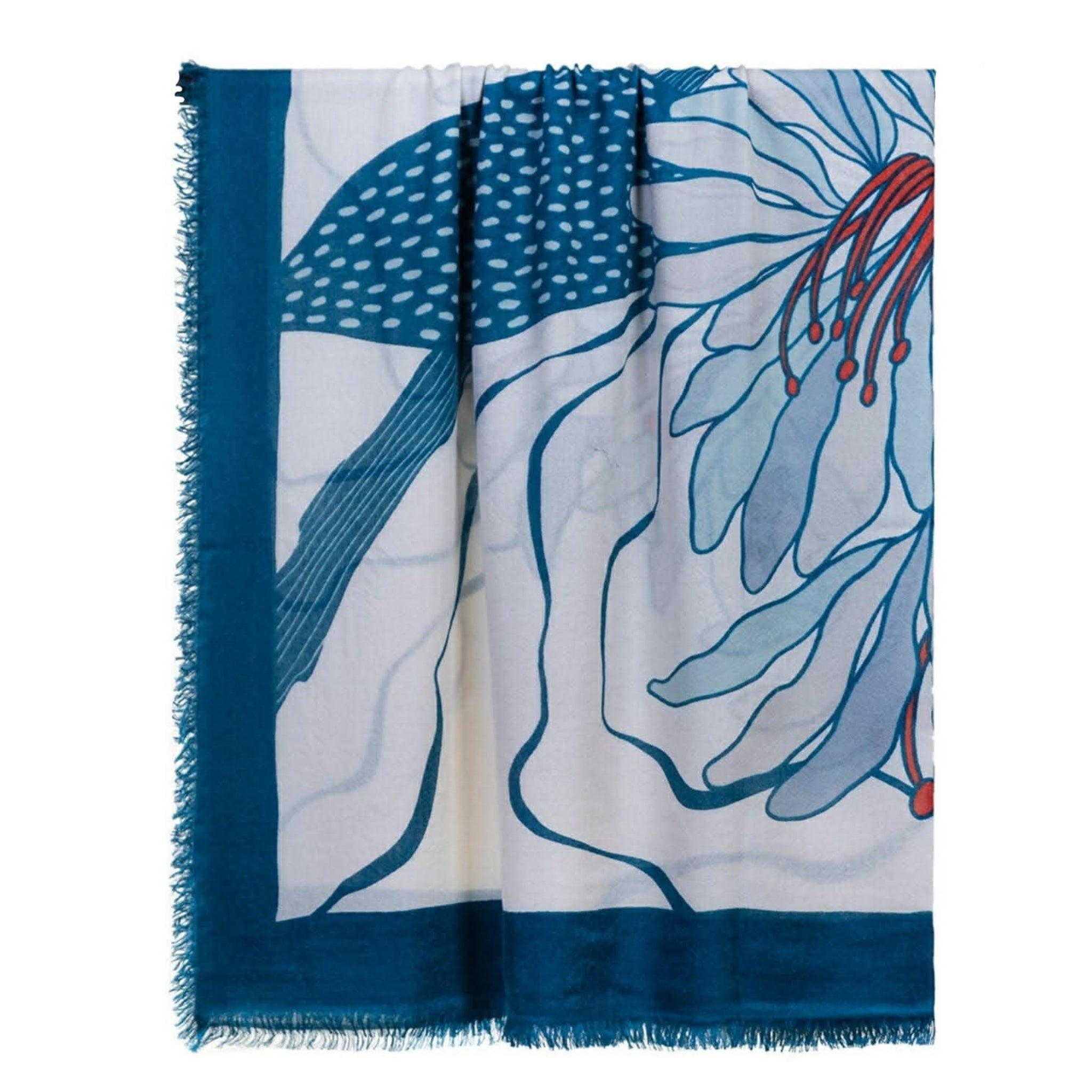 The Olympia Printed Square Scarf by OO-TO is handcrafted in Nepal with a bold floral design in teal, red, and blue tones, featuring fringed edges and a large flower print on a white background bordered in dark blue.