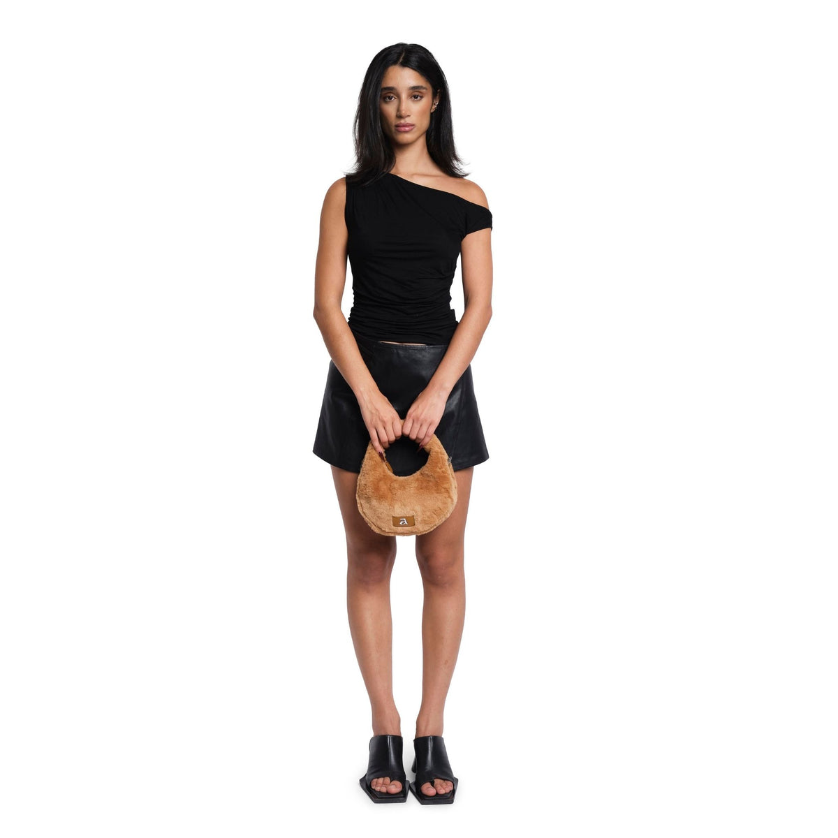 Woman holding a wooden handbag against a white background