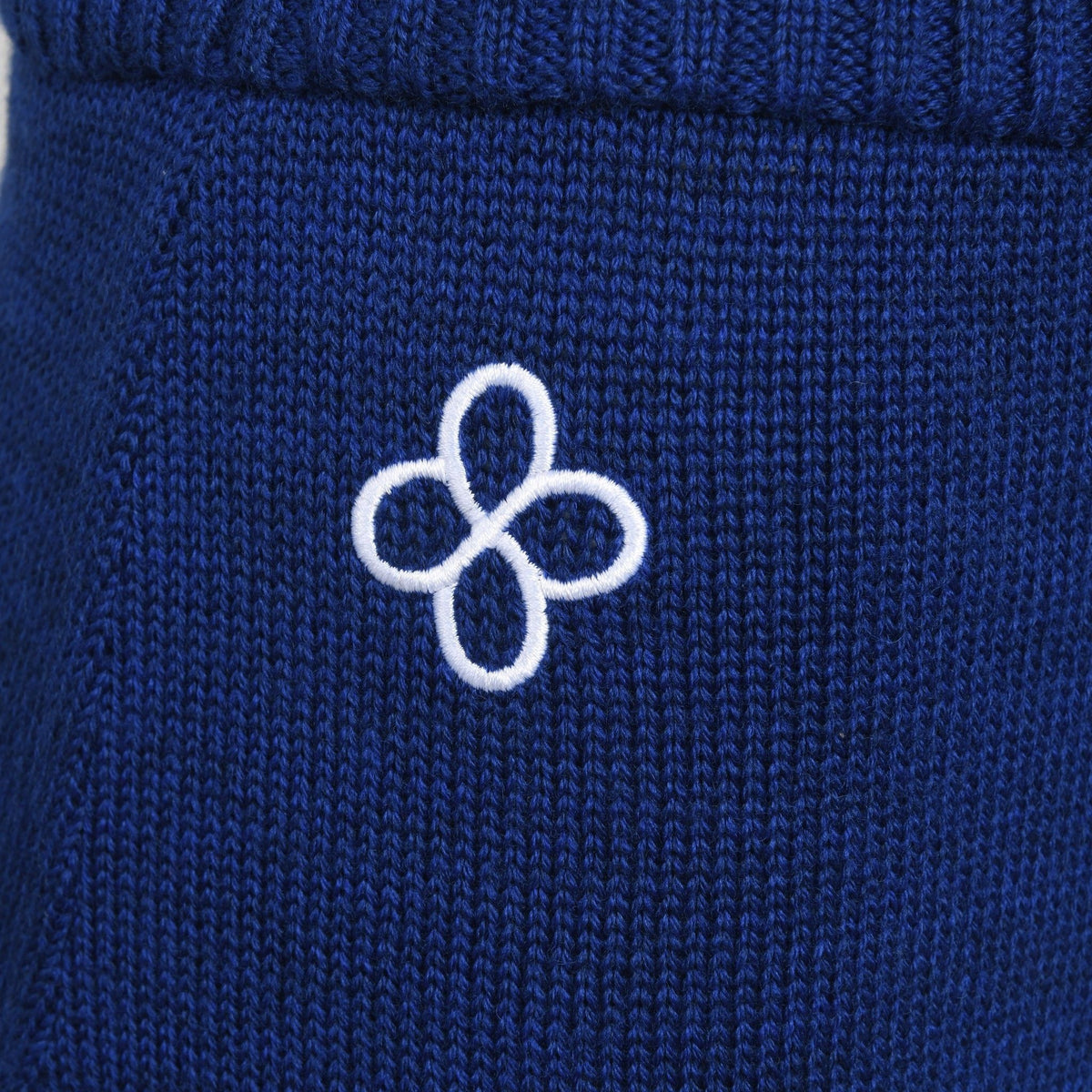 Close-up of a blue fabric with a white embroidered logo