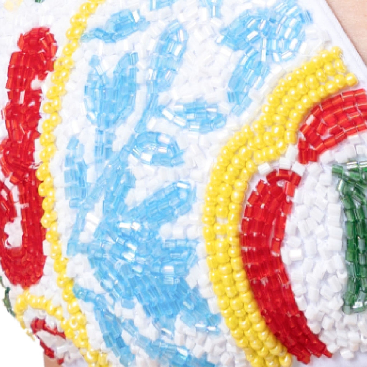 Close-up of the SELF-ADORE Limoncello Hand-Beaded Embellished Bikini Top in white, featuring a vibrant floral and curved pattern with blue, red, yellow, green, and white beads.