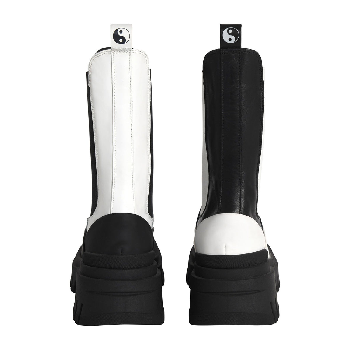 Black and white riding boots with a yin yang symbol on a white background