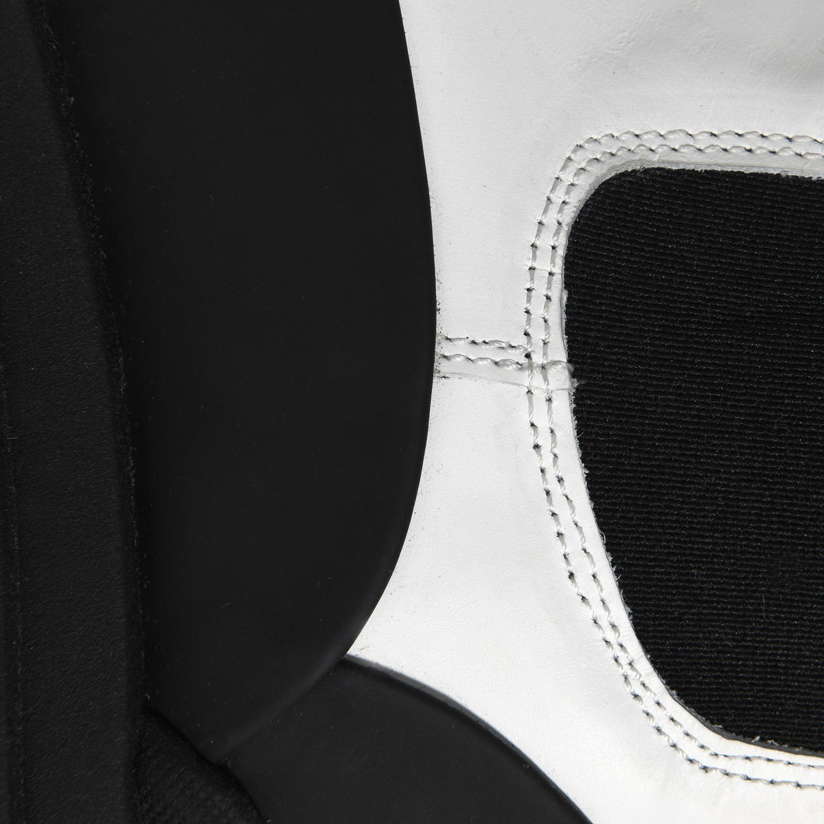 Close-up of a white boxing glove with black interior and stitching detail.