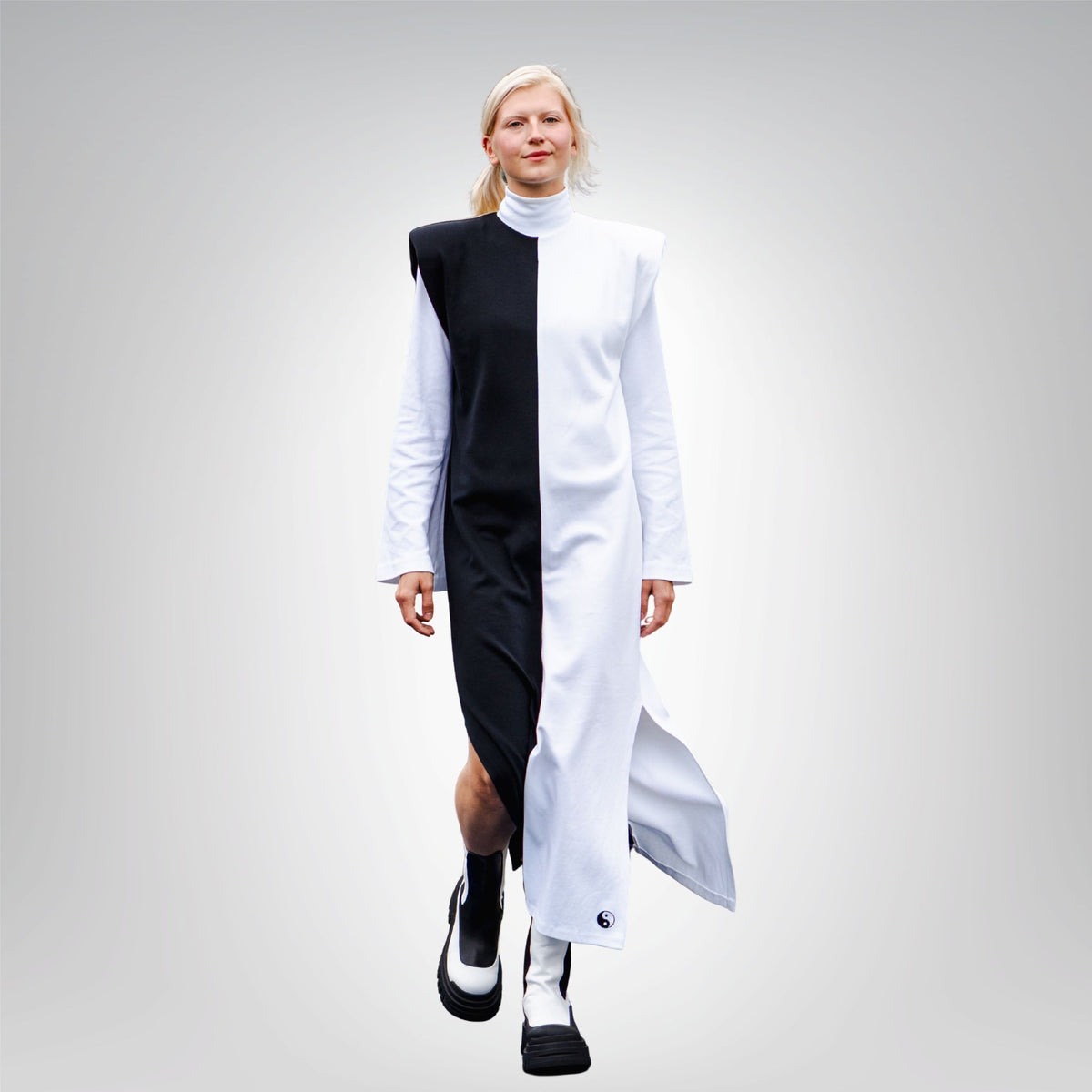 Person wearing a black and white outfit on a gray background