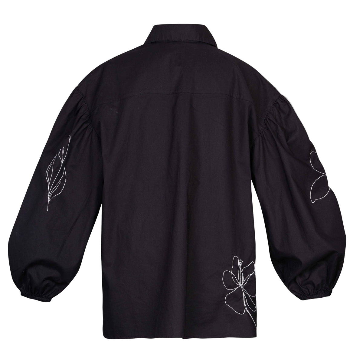 Black shirt with white floral embroidery on a light gray background