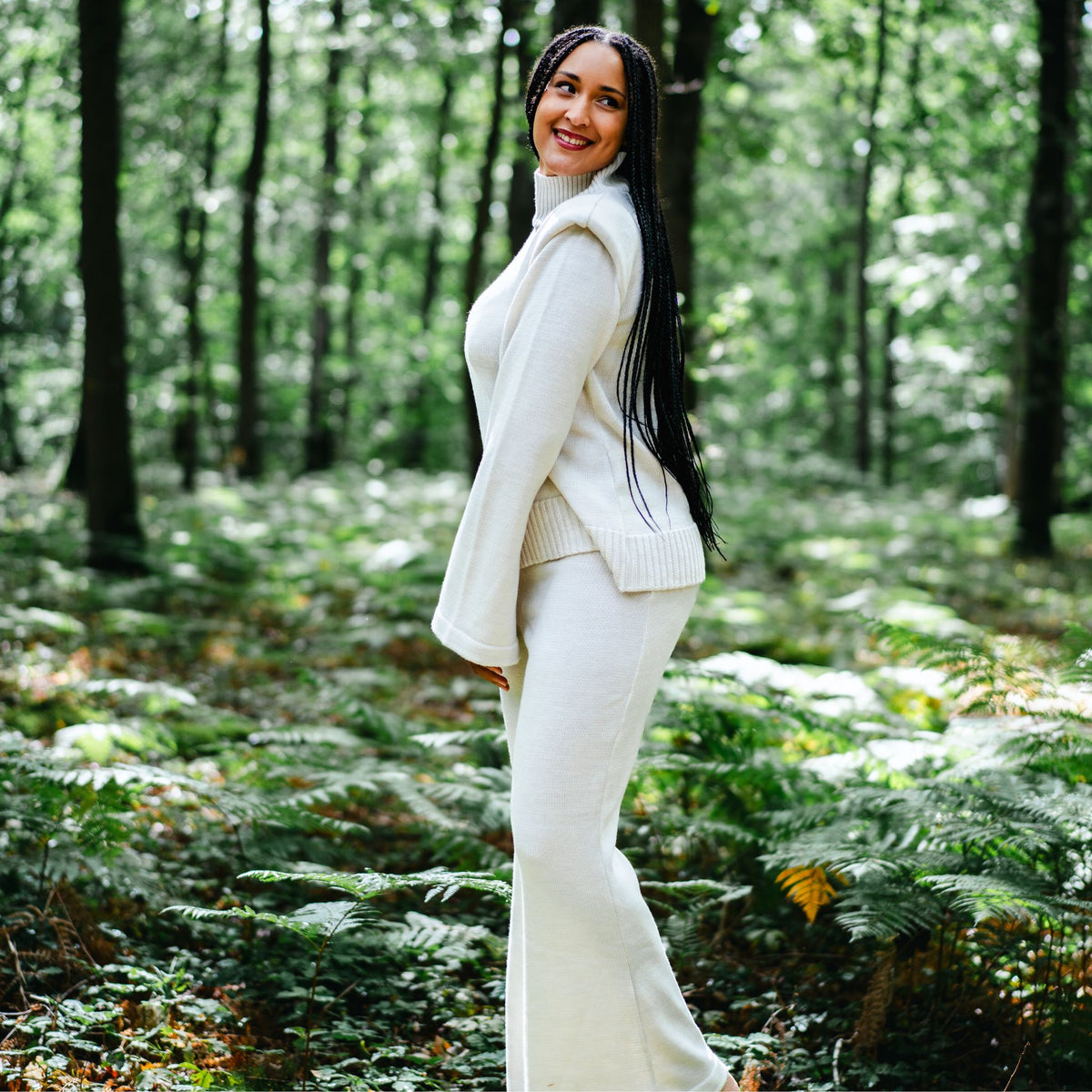 Woman in a white outfit standing in a forest