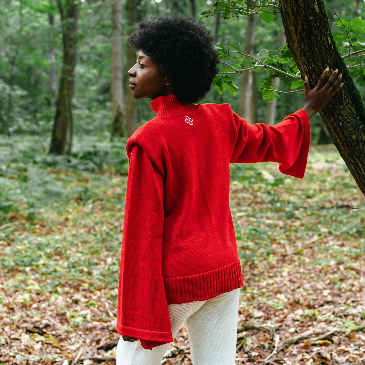 Person wearing a red sweater in a forest setting