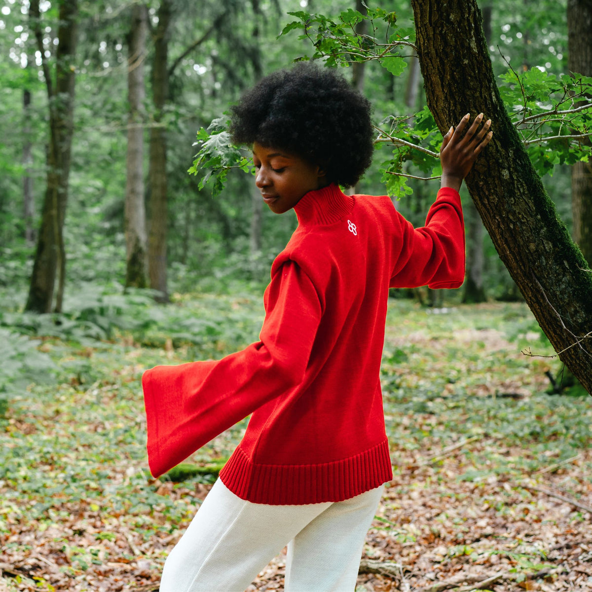 Person wearing a red sweater in a forest setting
