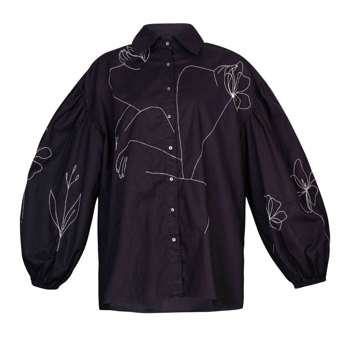 Black shirt with white floral embroidery on a light gray background