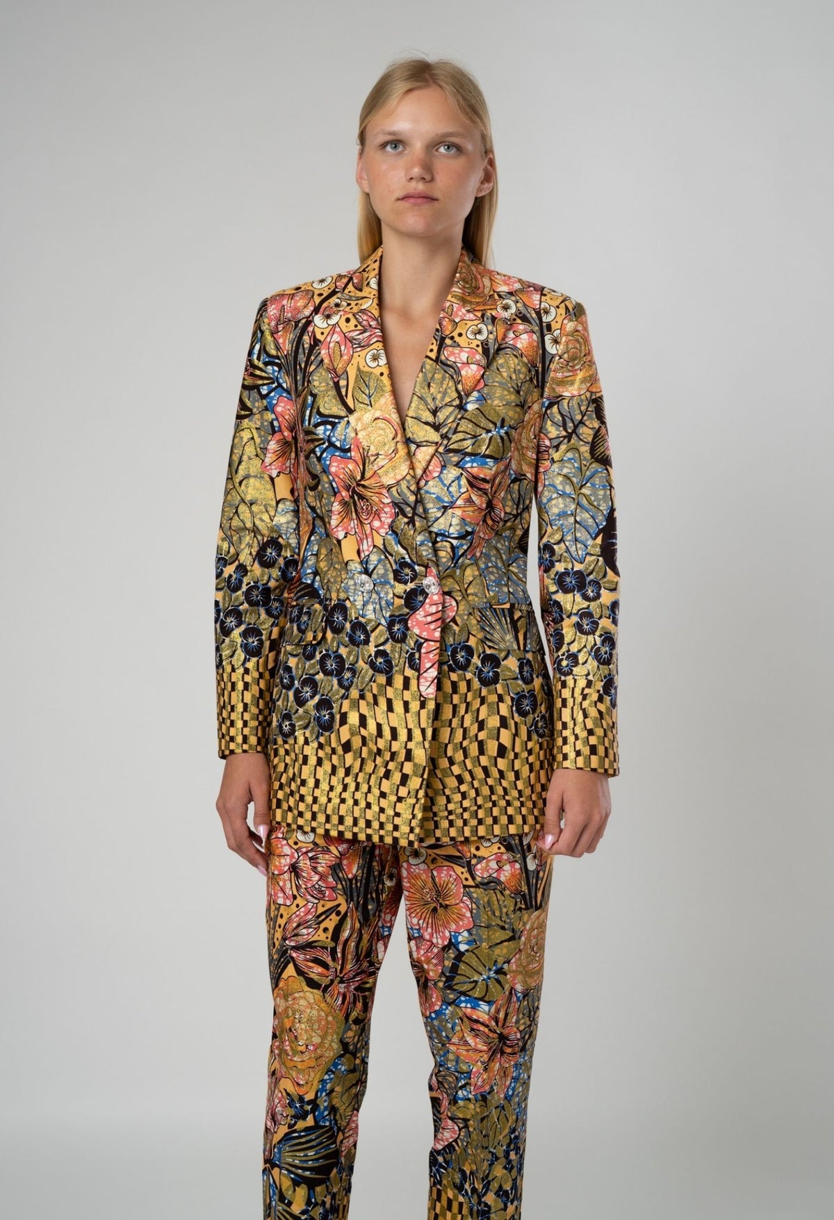 Woman wearing a floral patterned suit on a plain background