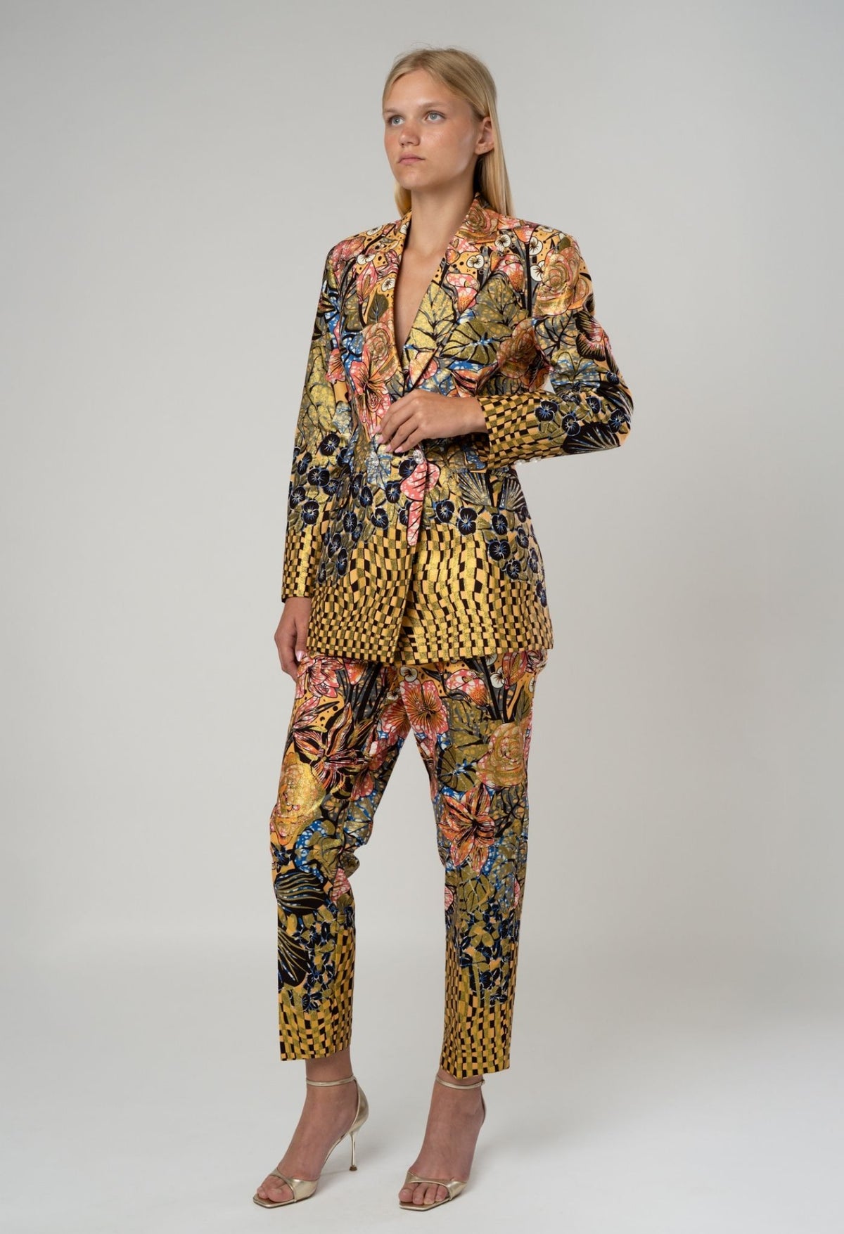 Woman wearing a colorful patterned suit on a white background