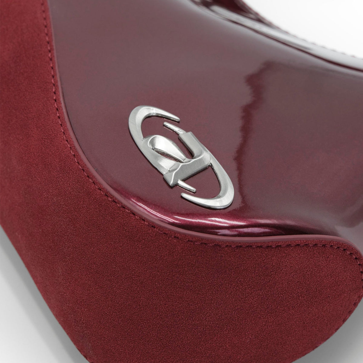 Close-up of a red handbag with a silver logo on a white background