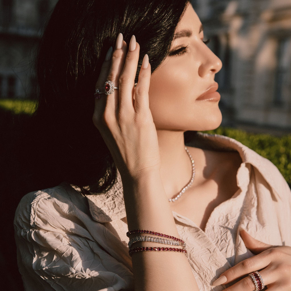 Woman wearing a pearl necklace and rings outdoors