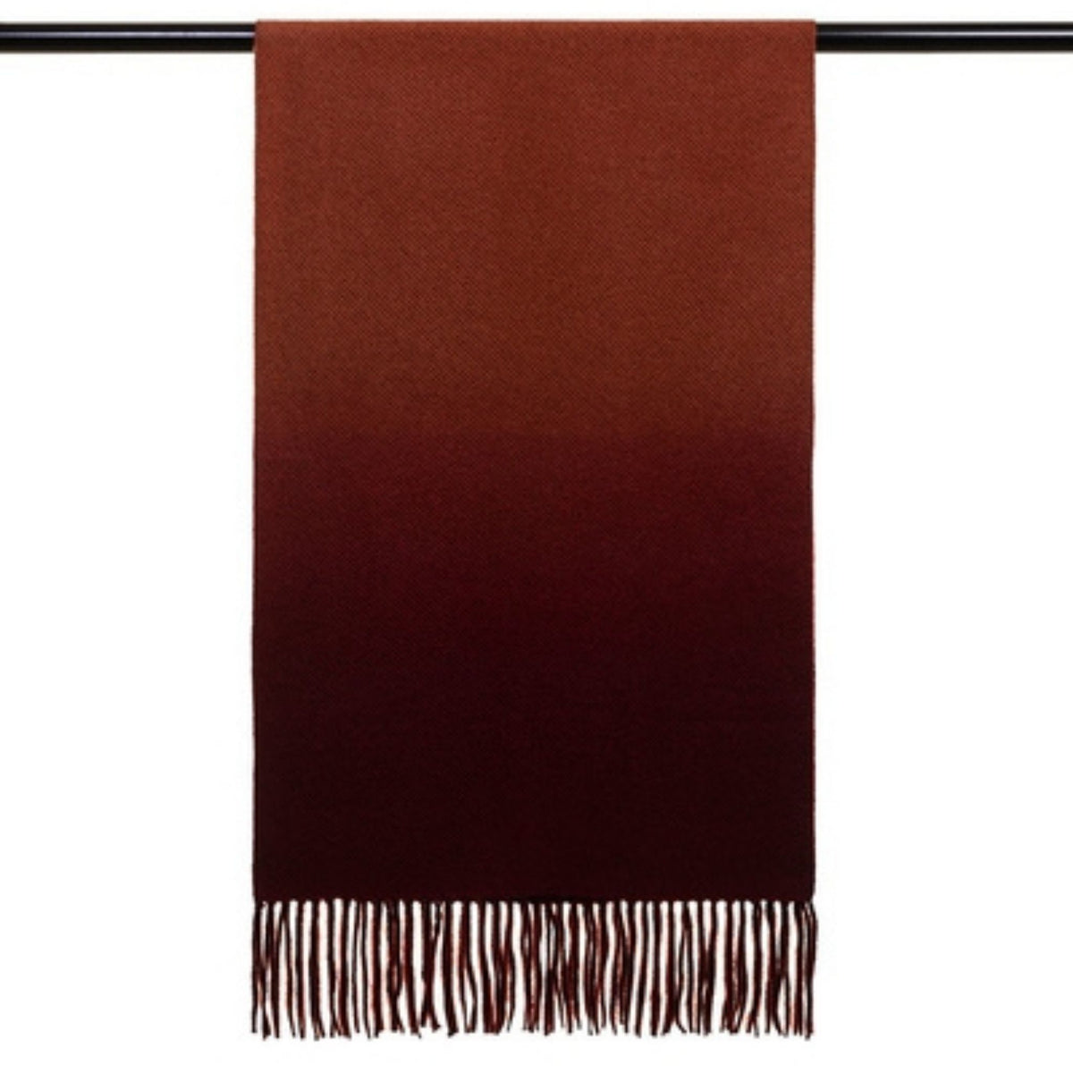 The OO-TO Standard Length Fringed Ombre Scarf in wine and rust hangs elegantly on a rod, its wool texture and artisanal detail adding warmth and character.