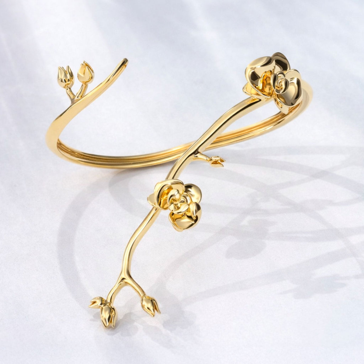 The Gold Floralis Bracelet from ANNA PRATA's AFlora Collection features a sculpted branch design with blooming flowers and buds, blending contemporary romance with nature-inspired elegance.