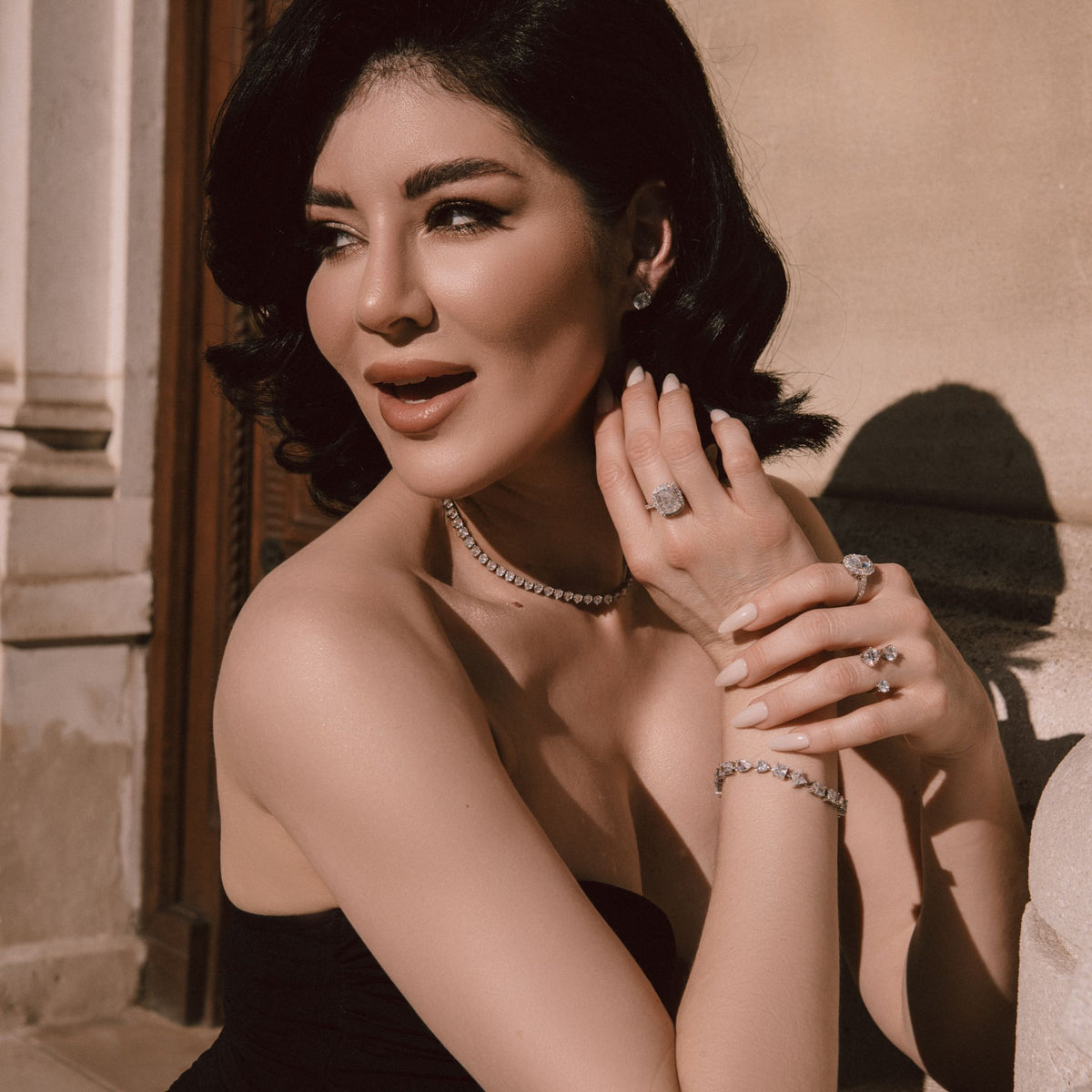 Woman wearing jewelry outdoors with a neutral background