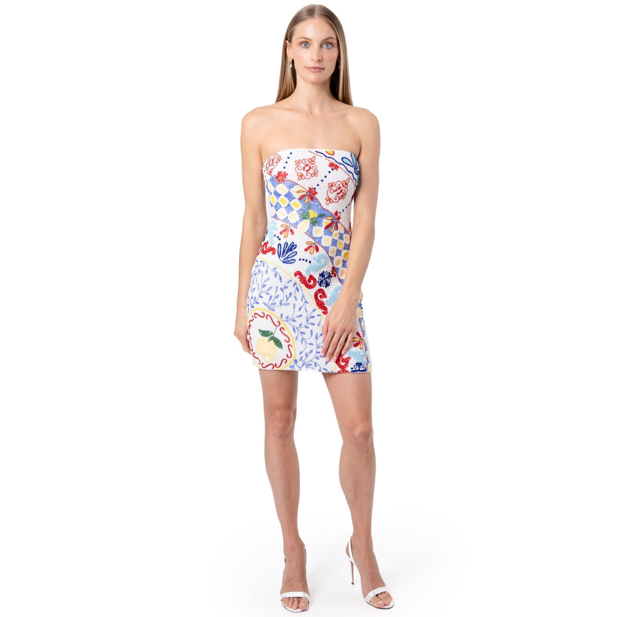 A woman with long straight hair wears the SELF-ADORE Senorita Hand-Beaded Embellished Mini Dress and white high-heeled sandals, standing against a plain white background, facing forward.