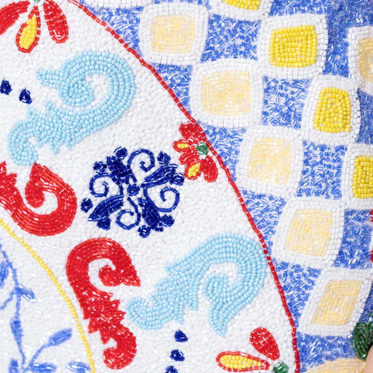 The SELF-ADORE Senorita Hand-Beaded Embellished Mini Dress showcases a vibrant mosaic pattern with blue, red, yellow, and turquoise tiles, swirling designs, geometric shapes, and striking square and floral motifs.