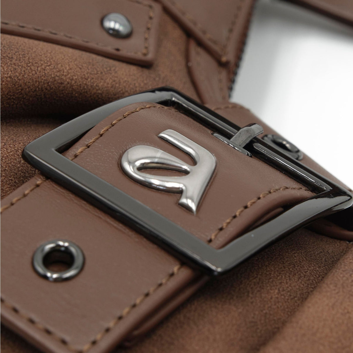 Close-up of a brown leather belt with a silver buckle featuring a logo.