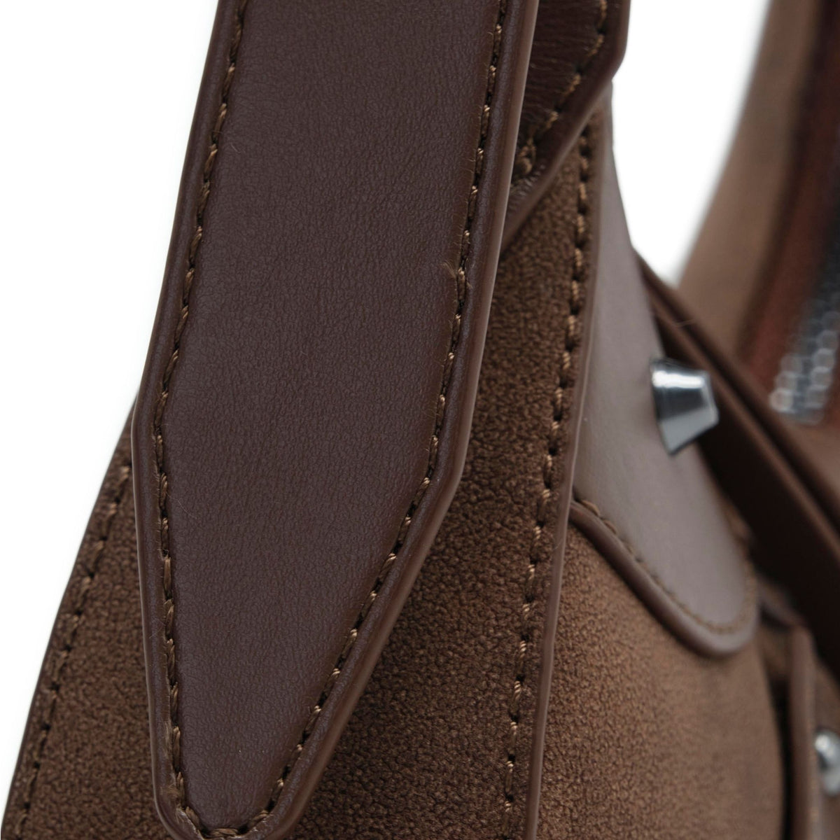Close-up of a brown textured handbag with leather strap and metal clasp.