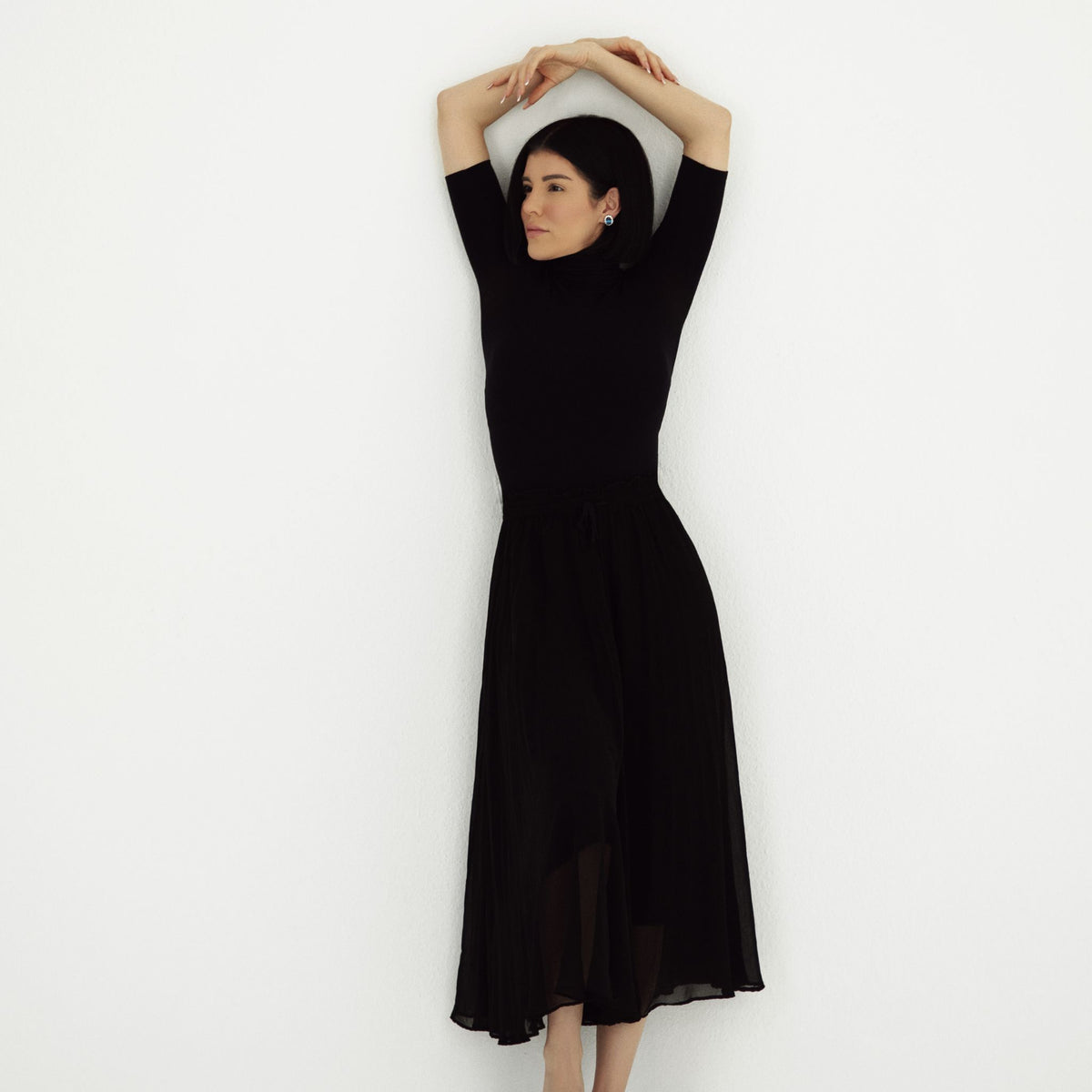 Woman wearing a black dress against a white background