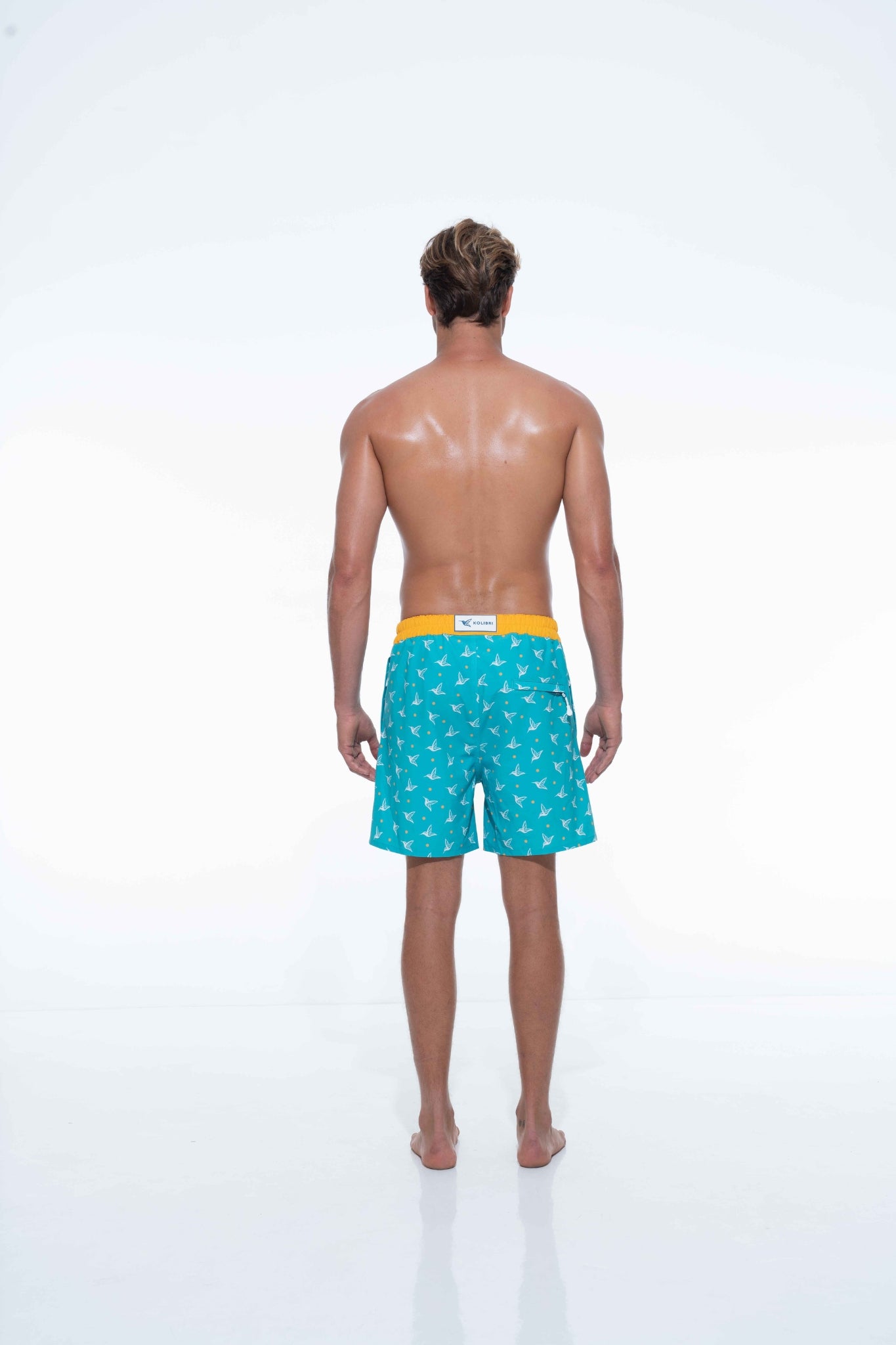 Model wearing Aquamarine monogram swim trunks
