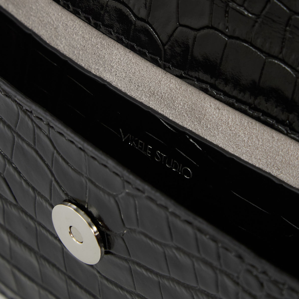 Close-up of a black textured handbag with &#39;Yikkle Studio&#39; branding.