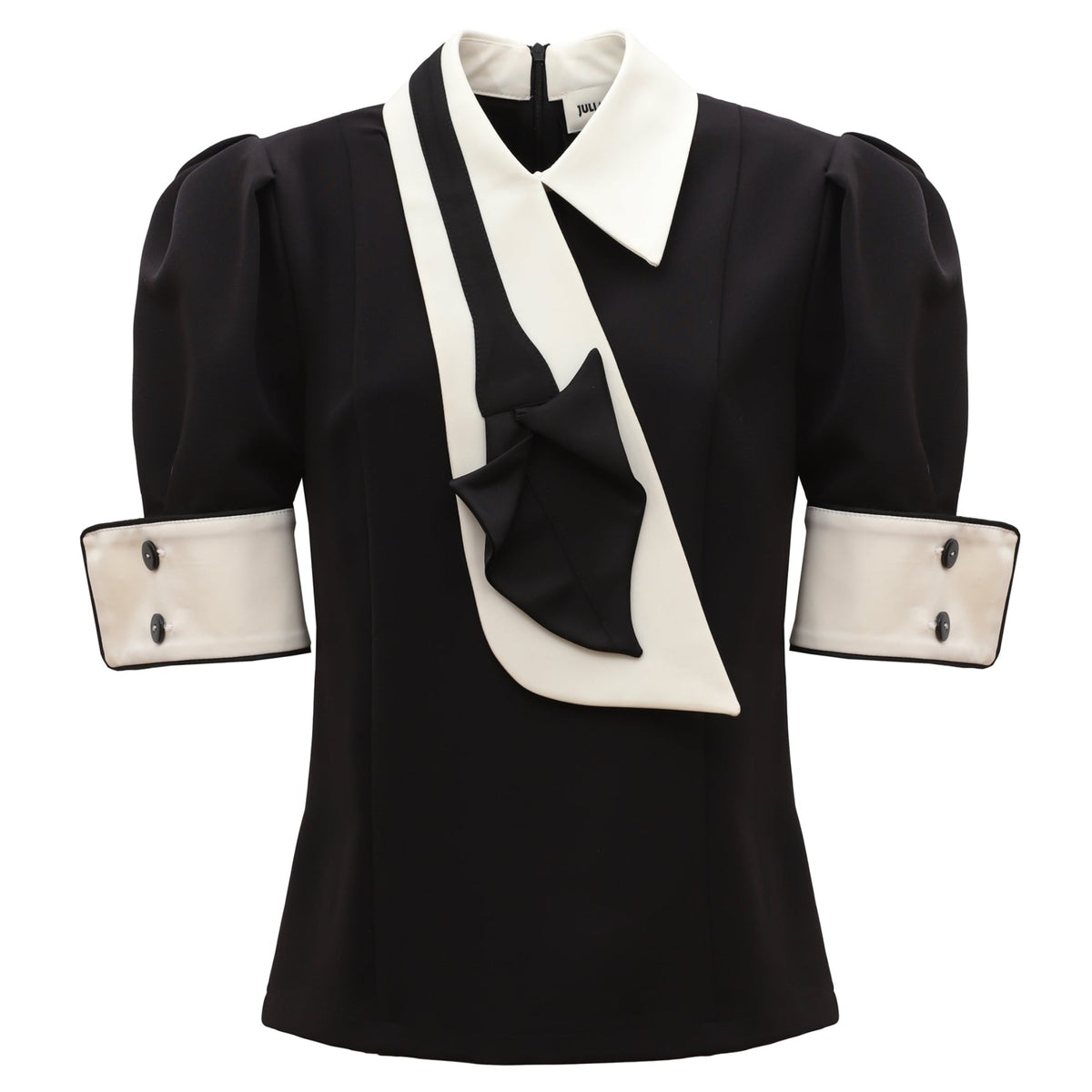 The JULIA ALLERT Statement Blouse With White Collar And Cuffs features puffed short sleeves, wide white cuffs with black buttons, a pointed collar, and an asymmetric white-and-black draped detail across the front.