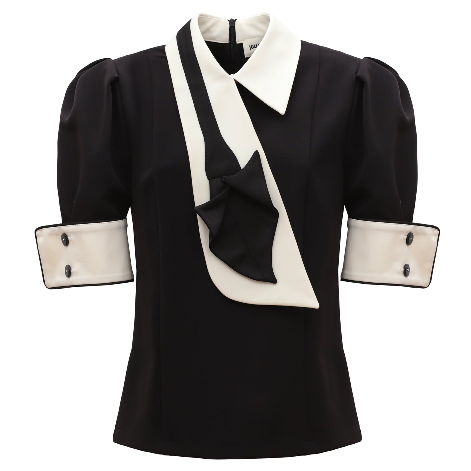 The JULIA ALLERT Statement Blouse With White Collar And Cuffs features puffed short sleeves, wide white cuffs with black buttons, a pointed collar, and an asymmetric white-and-black draped detail across the front.