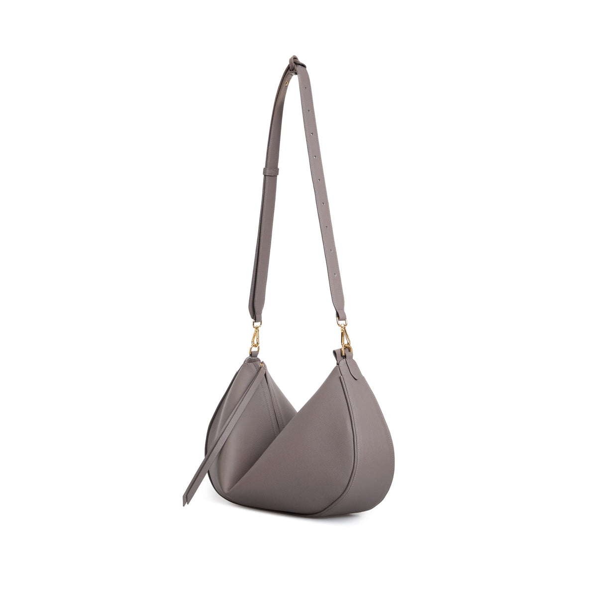The VIKELE STUDIO Denise Bag | Gray is a luxury handbag in gray leather with a crescent shape, adjustable strap, gold hardware, and zipper closure. This elegant bag stands upright on a white background.