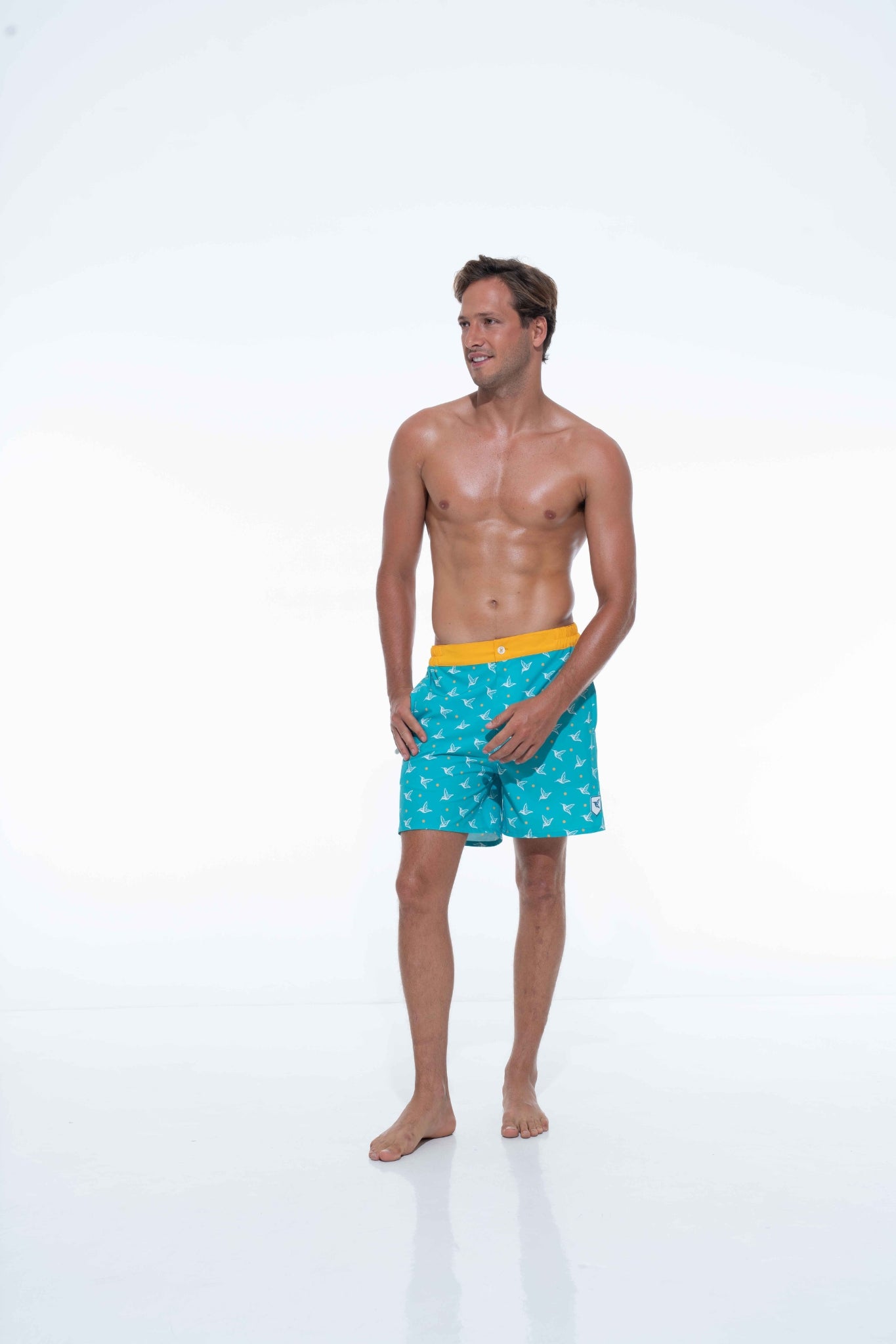 Model wearing Aquamarine monogram swim trunks