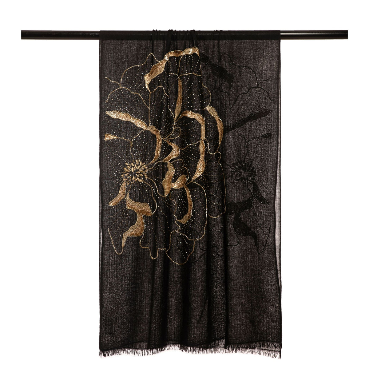 The Black Blythe Flower Embroidered Stole by OO-TO is a luxury black scarf handmade in Nepal, featuring an intricate gold floral design and subtle fringe—perfect for elevating any look.