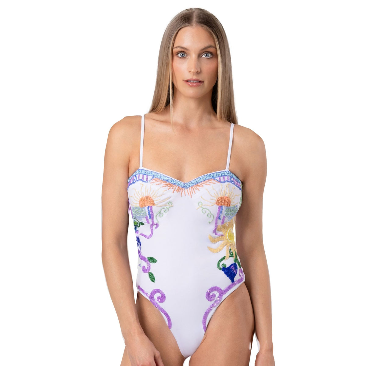 A woman with straight, long blonde hair wears the SELF-ADORE Serenity Hand-Beaded Embellished One-Piece Swimsuit with colorful floral and abstract designs, standing facing forward against a plain white background.