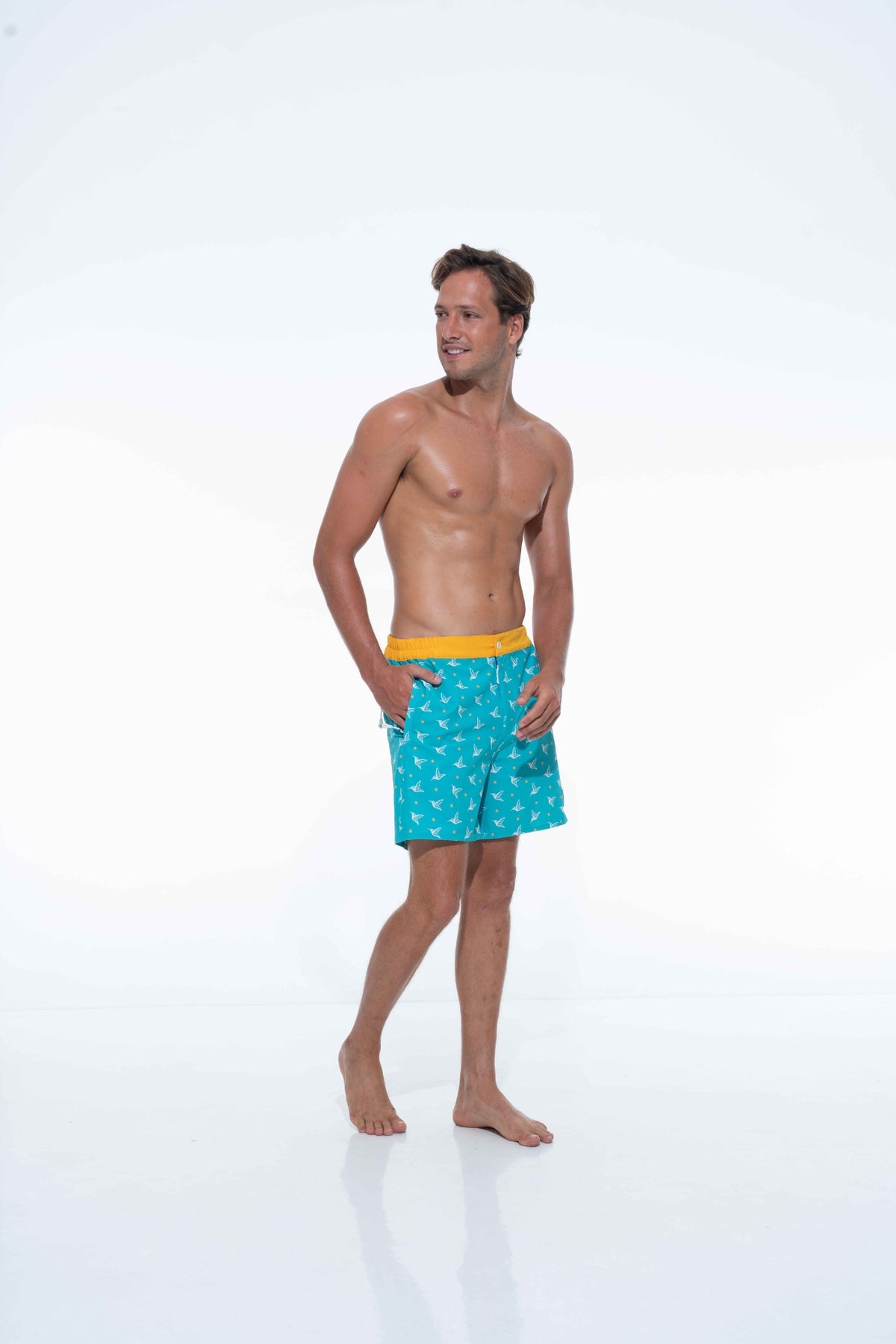 Model wearing Aquamarine monogram swim trunks
