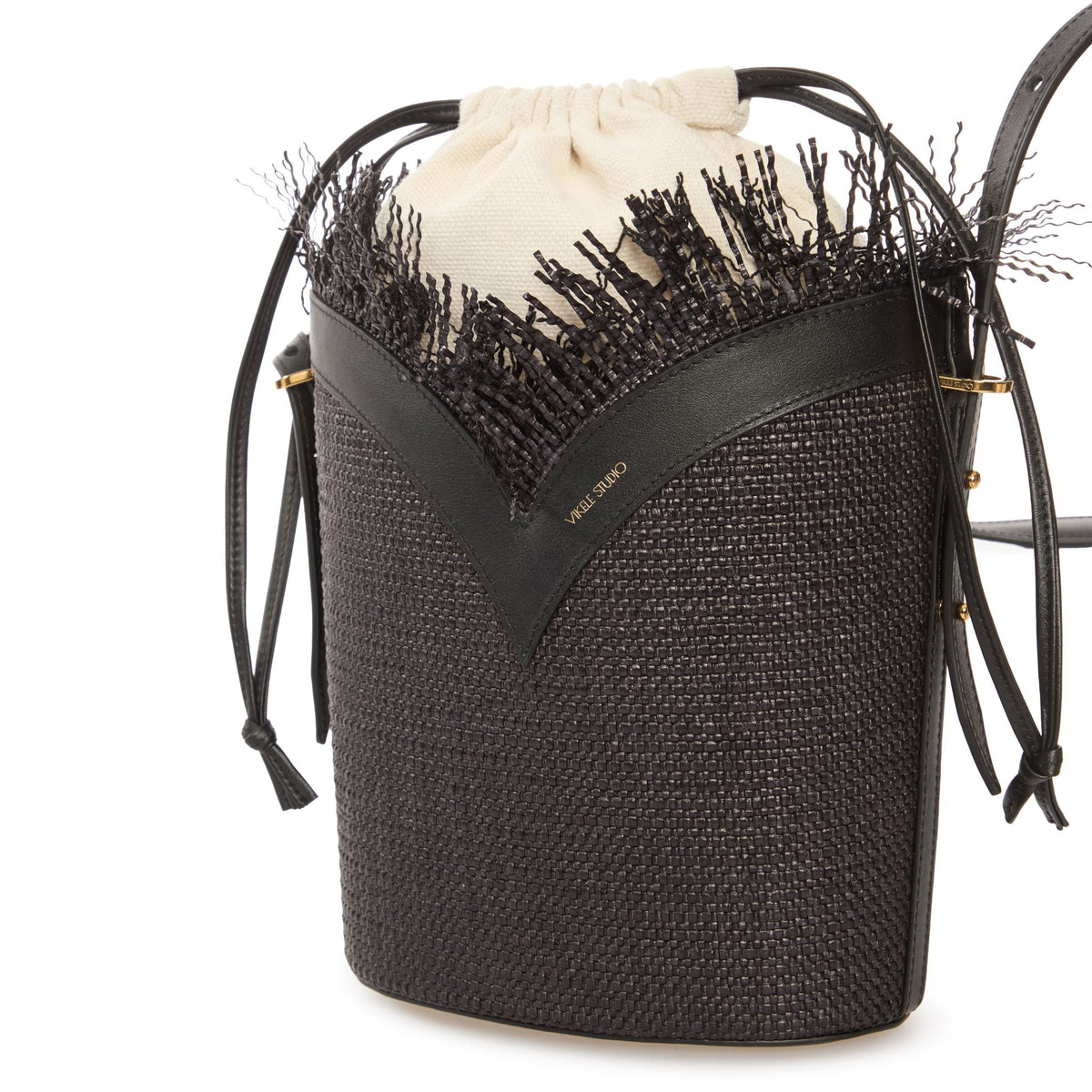 Black woven bucket bag with black fringe and drawstring on a white background