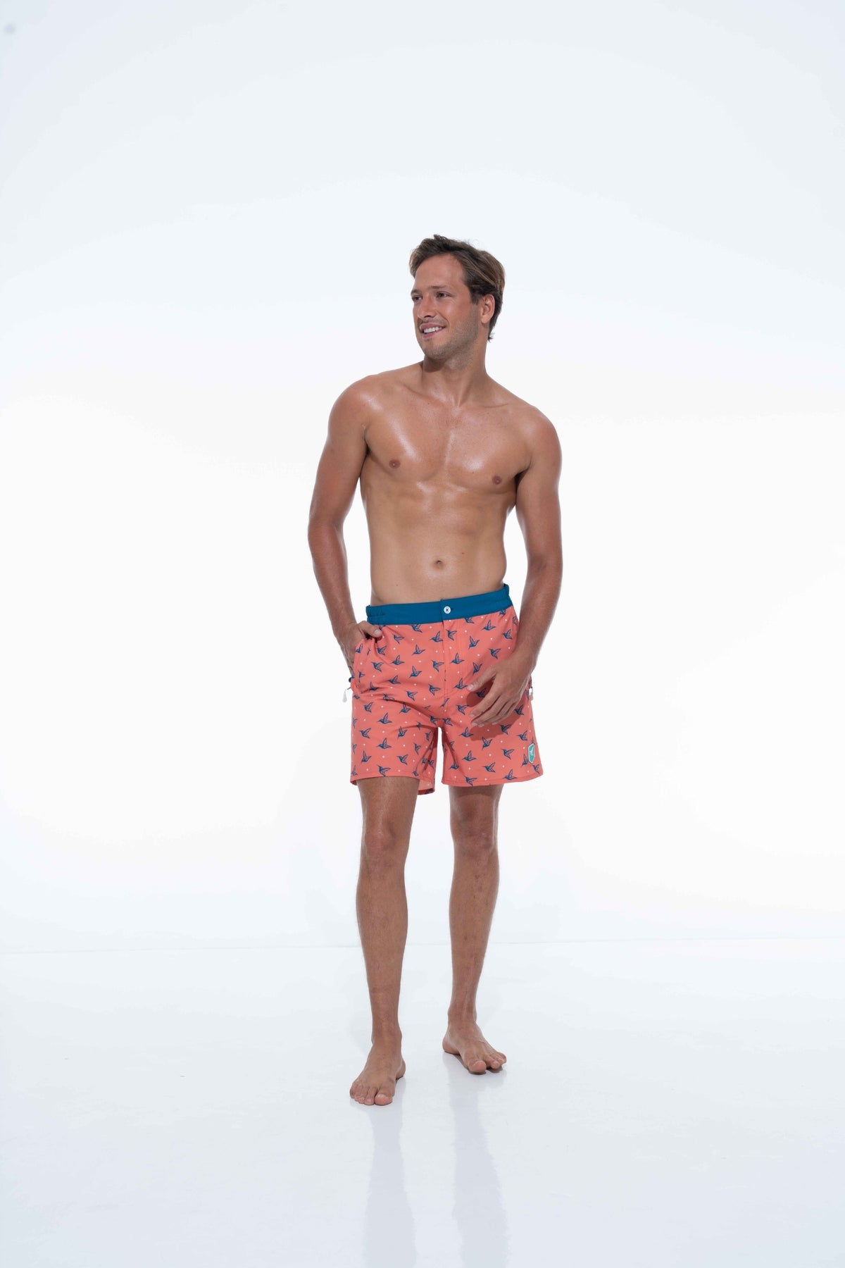Model wearing Sunset Orange monogram swim trunks