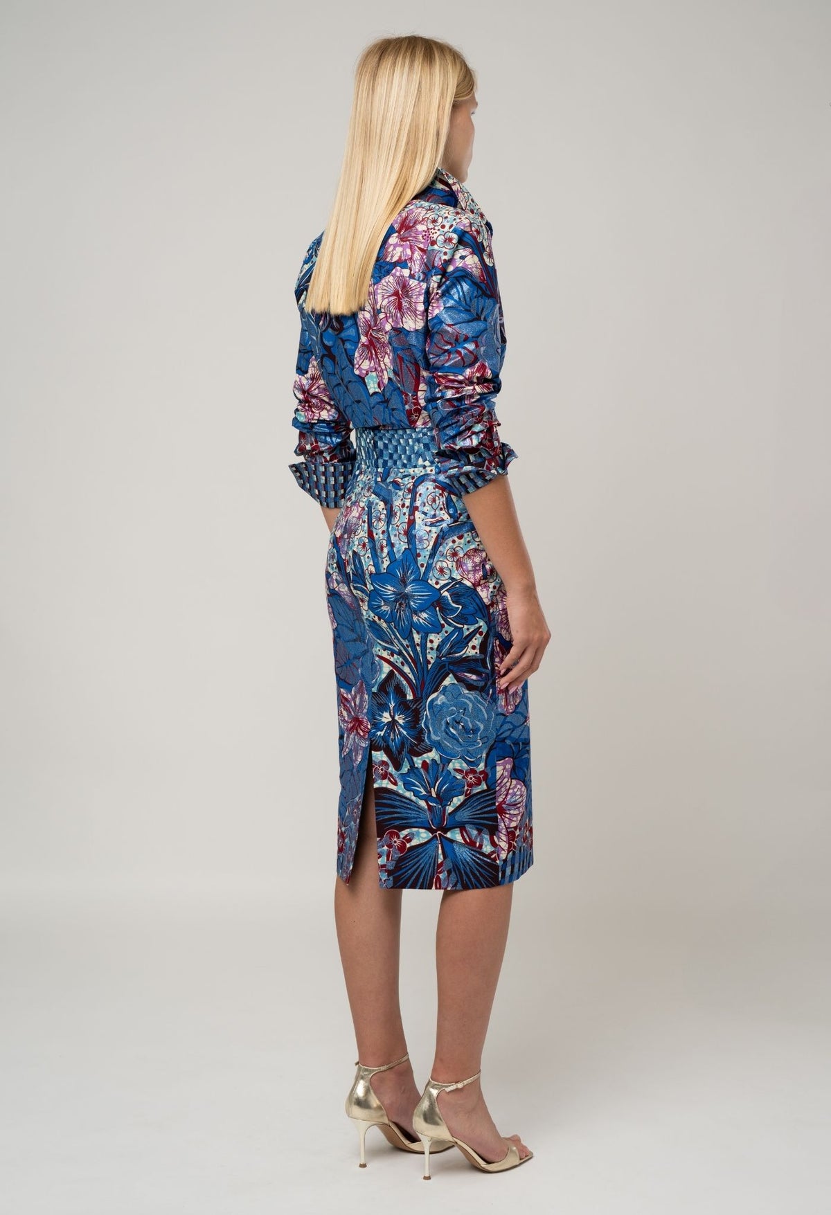 Woman wearing a blue floral dress on a plain background