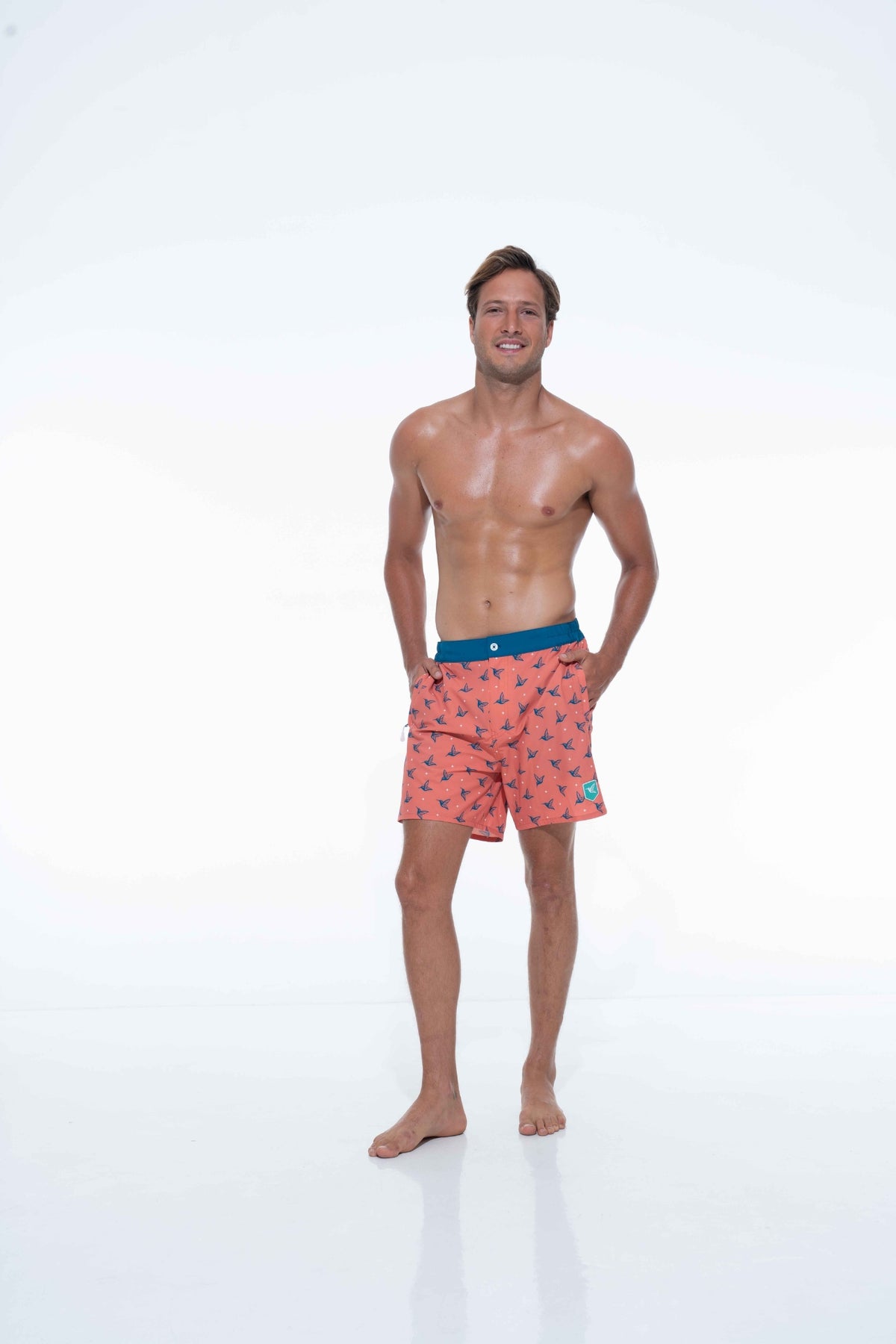Model wearing Sunset Orange monogram swim trunks