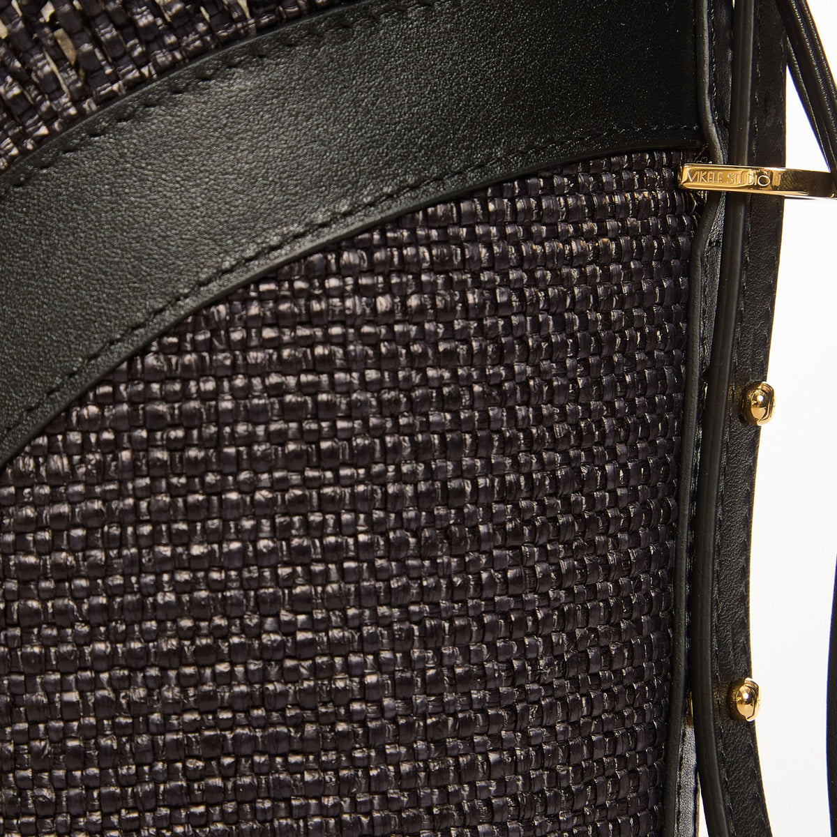 Close-up of a textured black handbag with leather accents