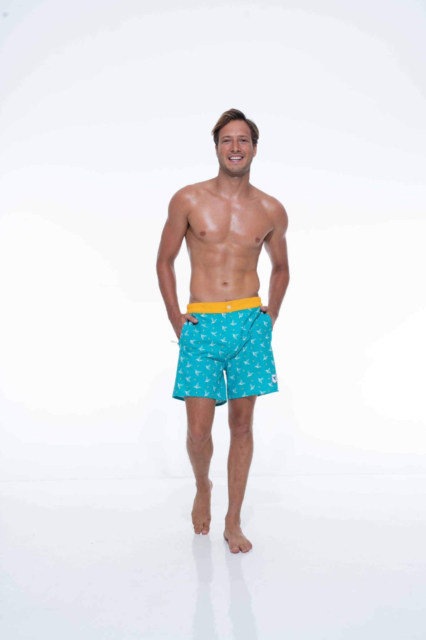 Model wearing Aquamarine monogram swim trunks