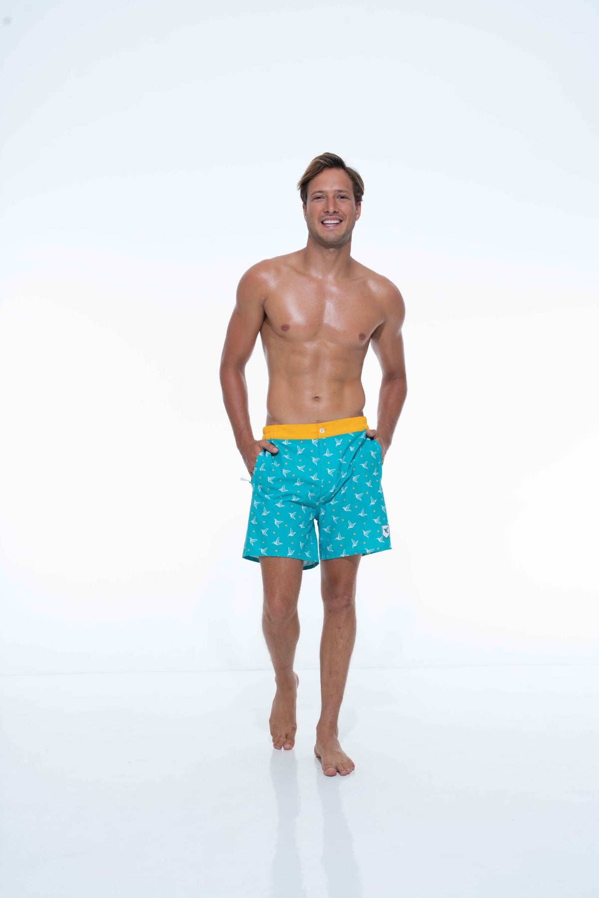 Model wearing Aquamarine monogram swim trunks