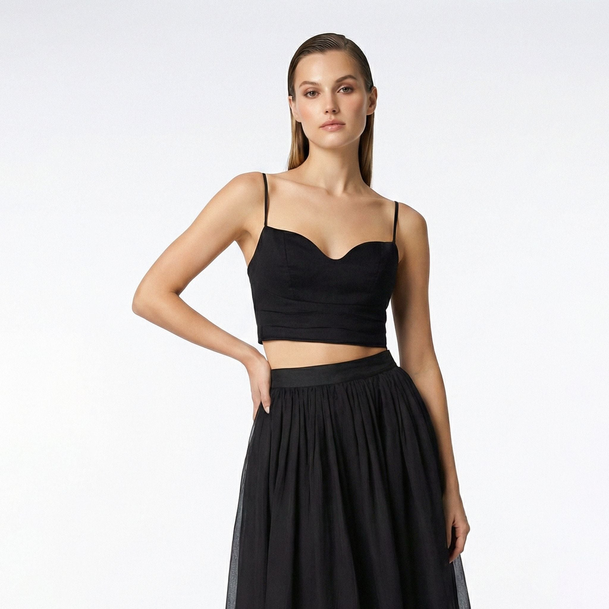 Woman wearing a black top and black skirt on a white background