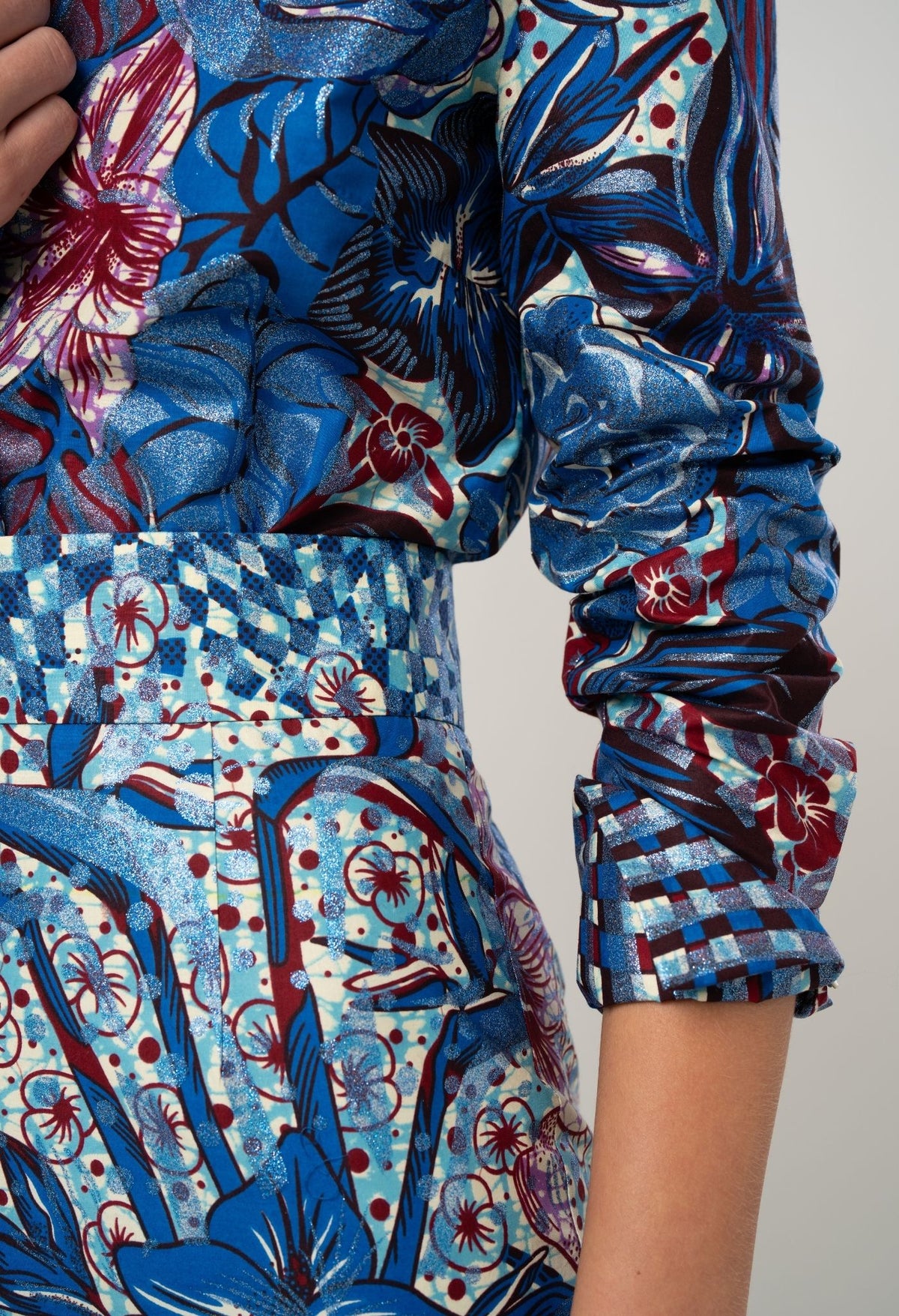 Close-up of a person wearing a colorful floral-patterned outfit with blue as the dominant color.