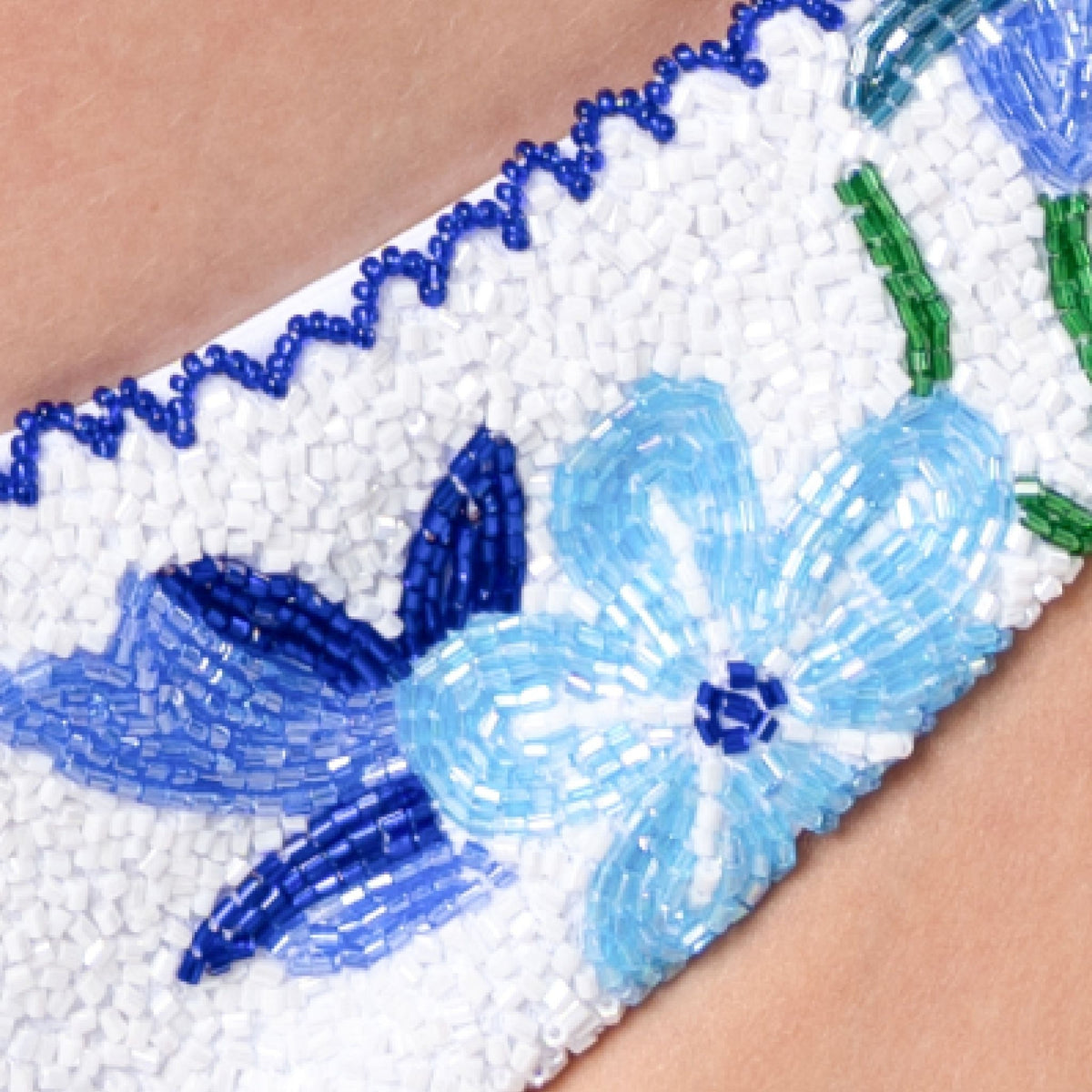 Close-up of the SELF-ADORE Euro Summer Hand-Beaded Embellished Bikini Bottom in blue, featuring a floral bead pattern with light blue flowers and green stems—an ideal choice for chic European summer swimwear.