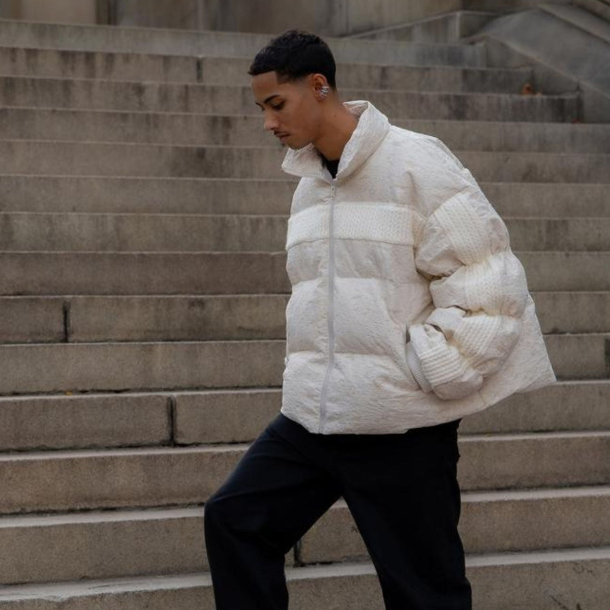 Person wearing a white puffer jacket on stone steps