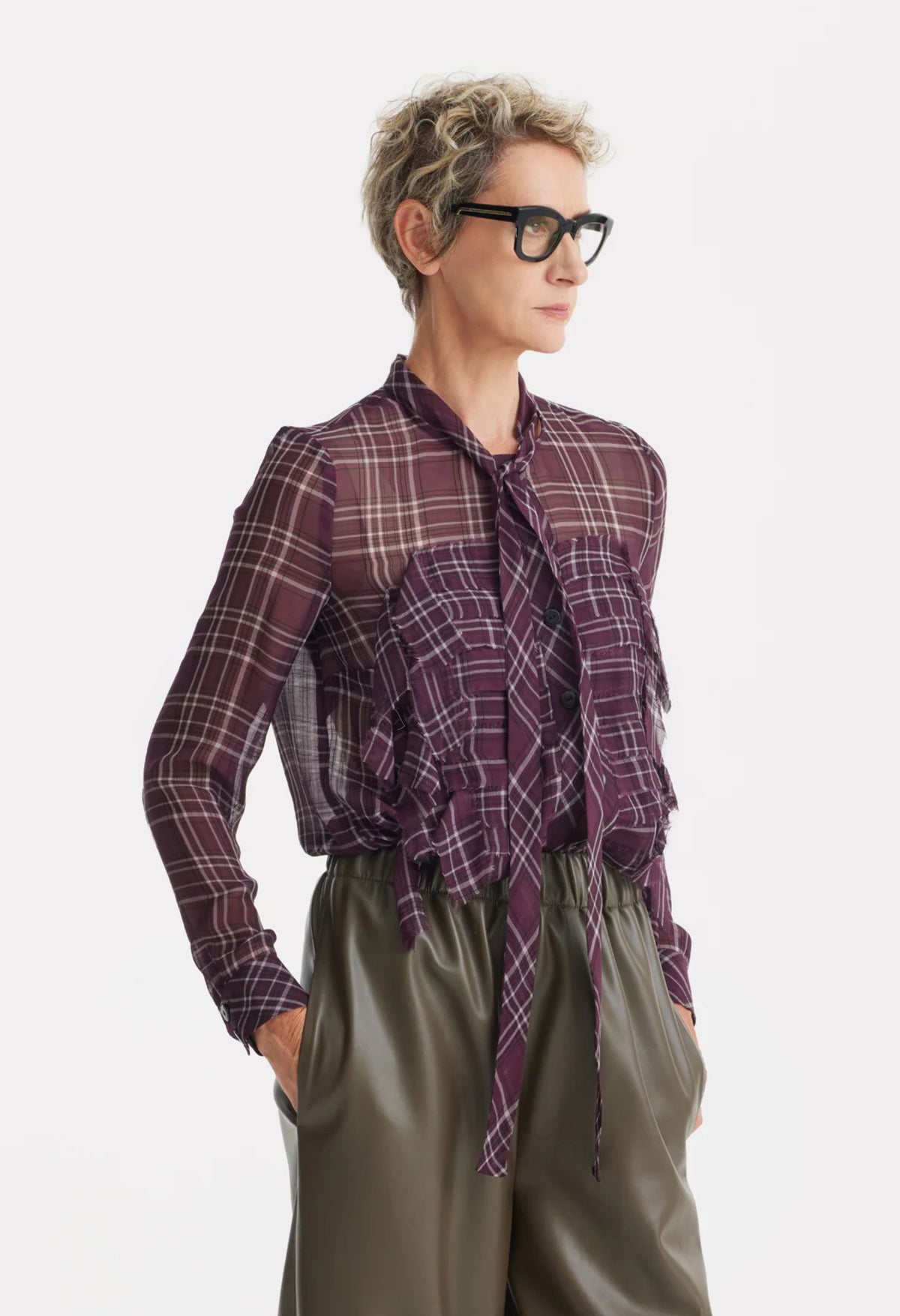 Person wearing a plaid shirt and glasses on a white background