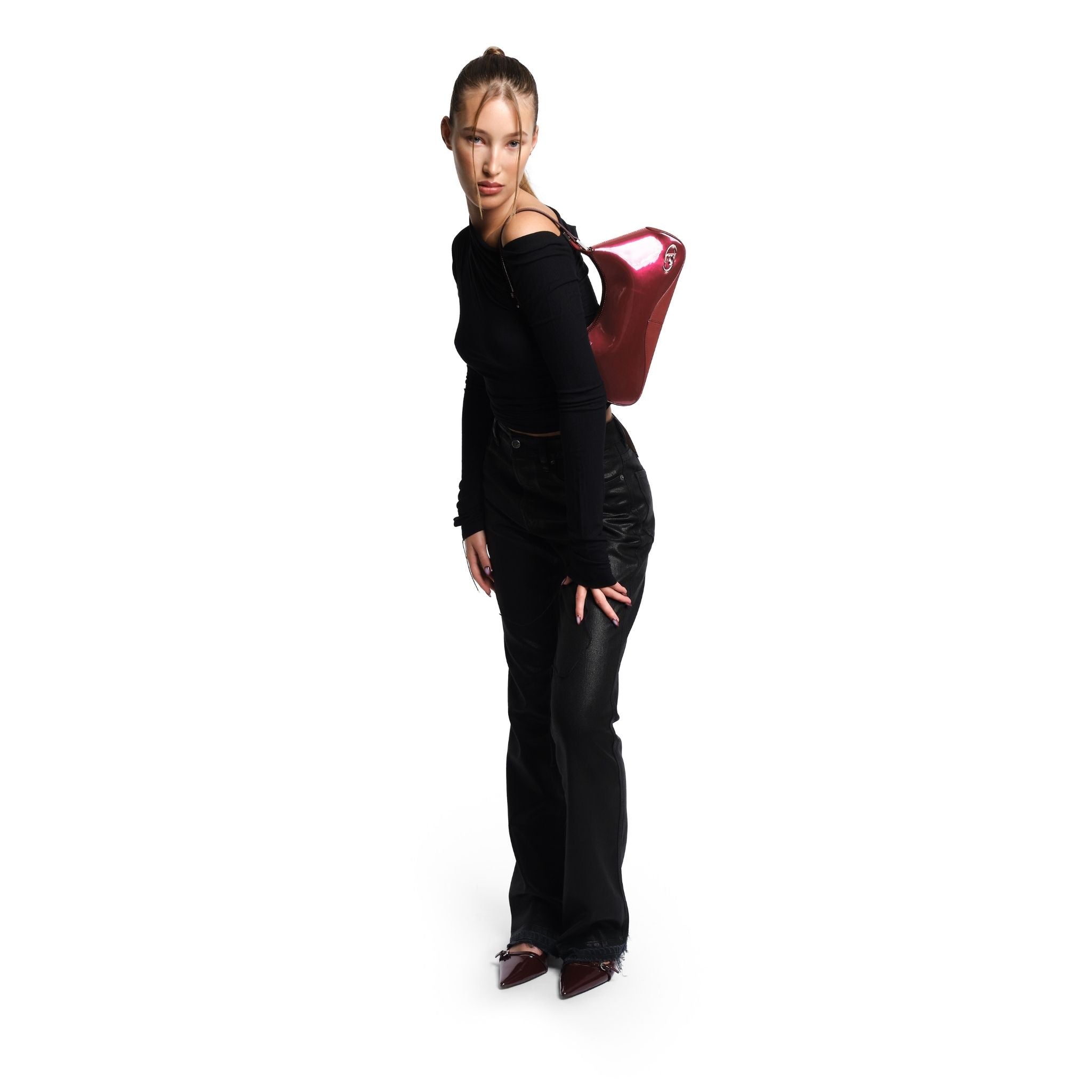Woman in black outfit holding a red handbag on a white background