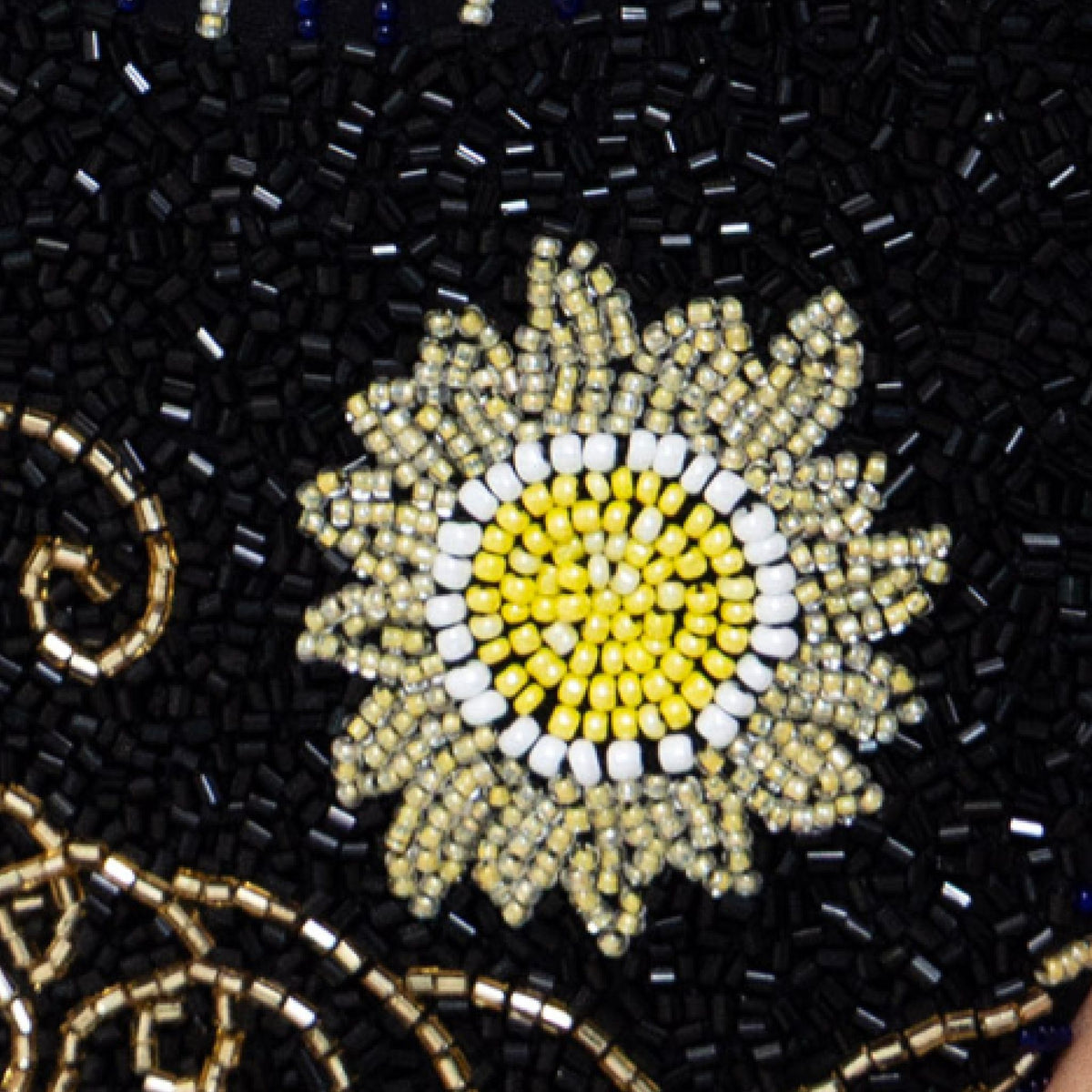 The Dark Tide Hand-Beaded Embellished Bikini Bottom by SELF-ADORE features a beaded sunflower in yellow, white, and gold on a black backdrop with swirling gold accents for a celestial-inspired swimwear look.