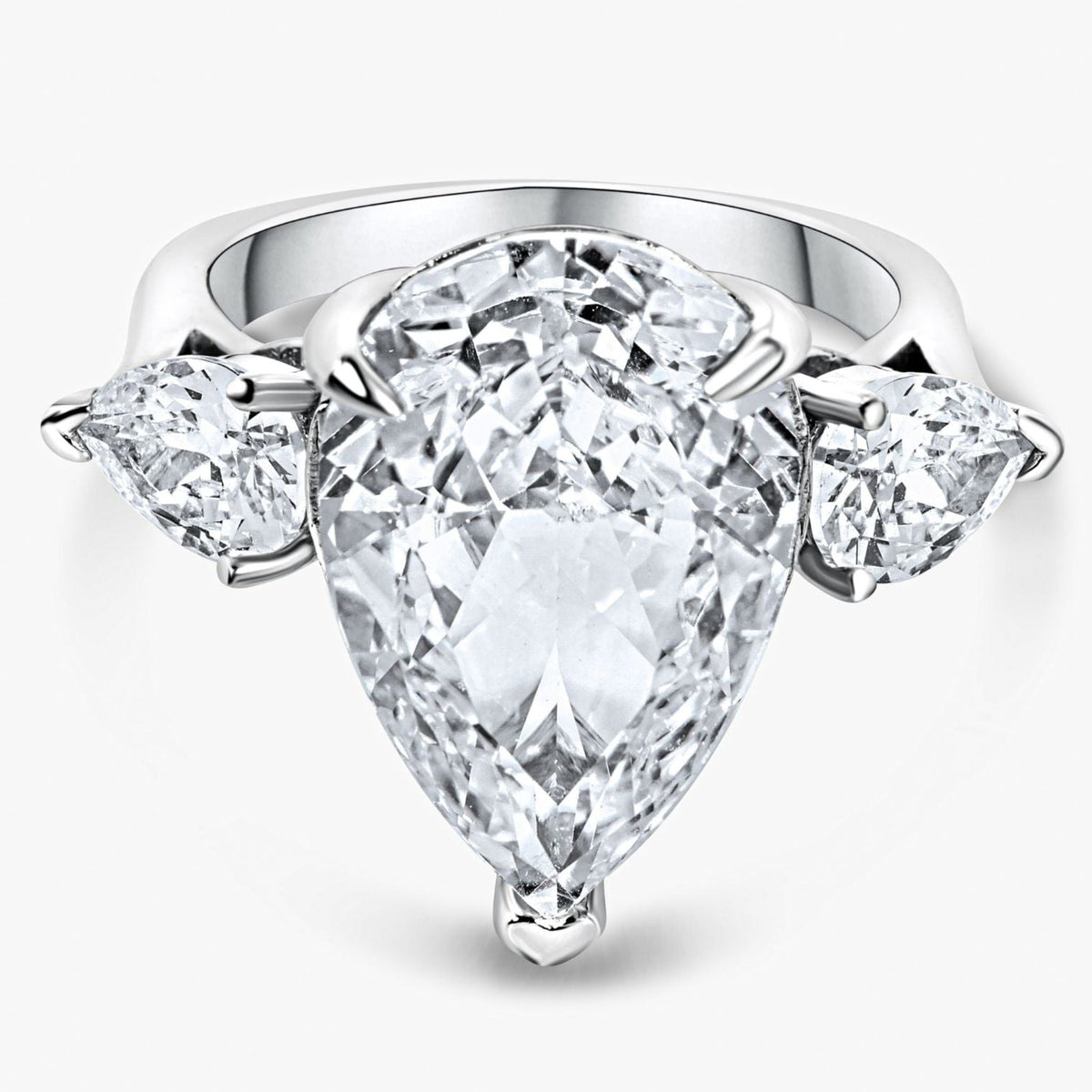 Diamond ring with a pear-shaped center stone and two side stones on a white background